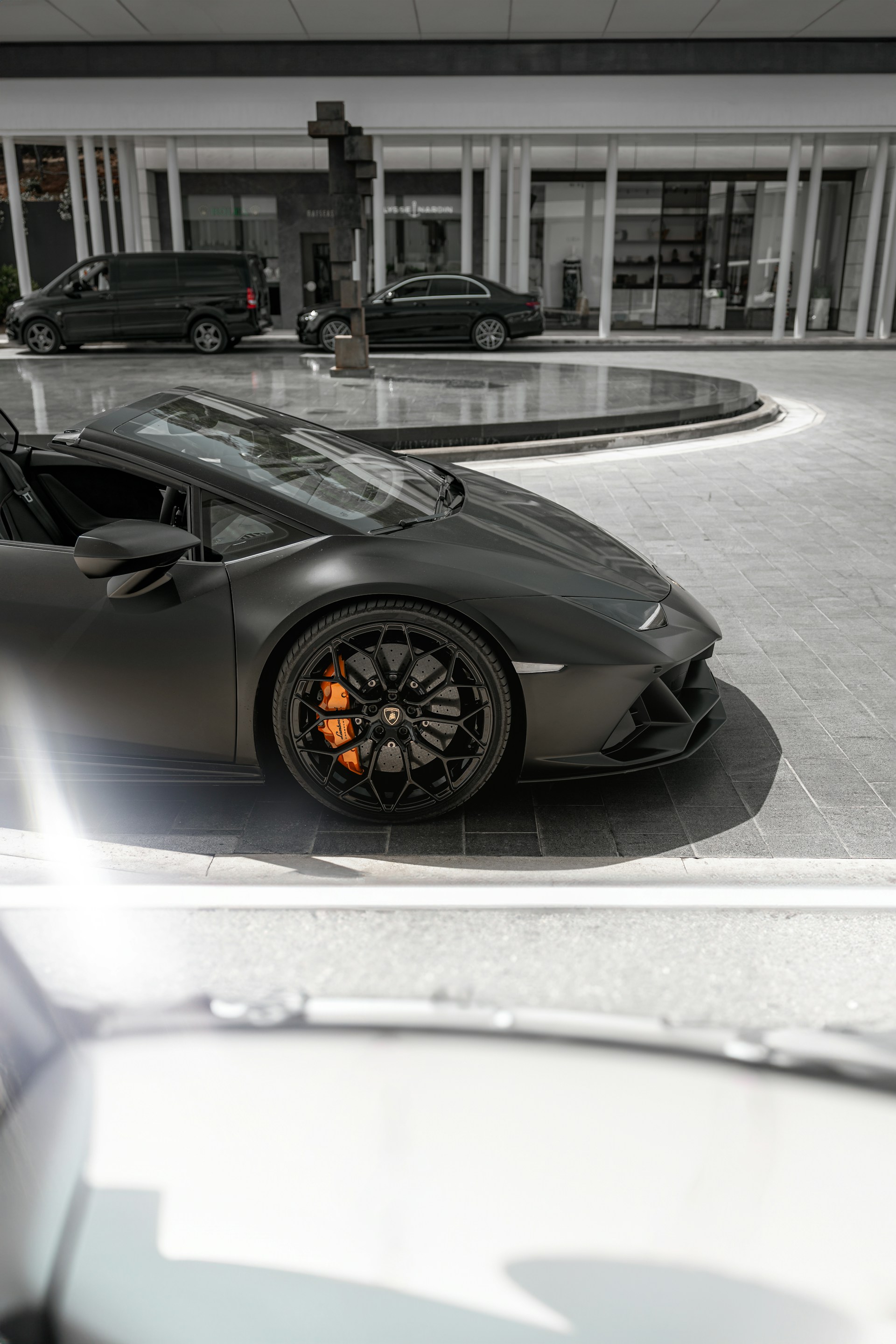 A grey sports car parked in front of a building