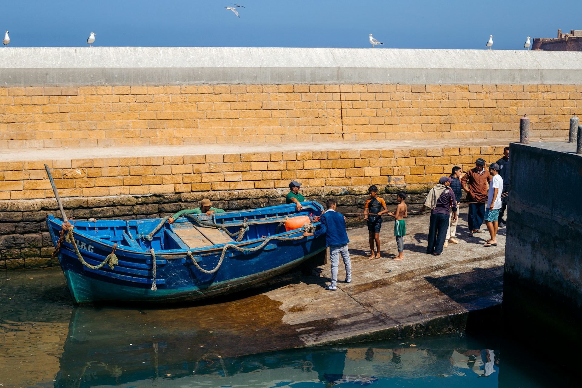 A group of people standing on a dock next to a boat