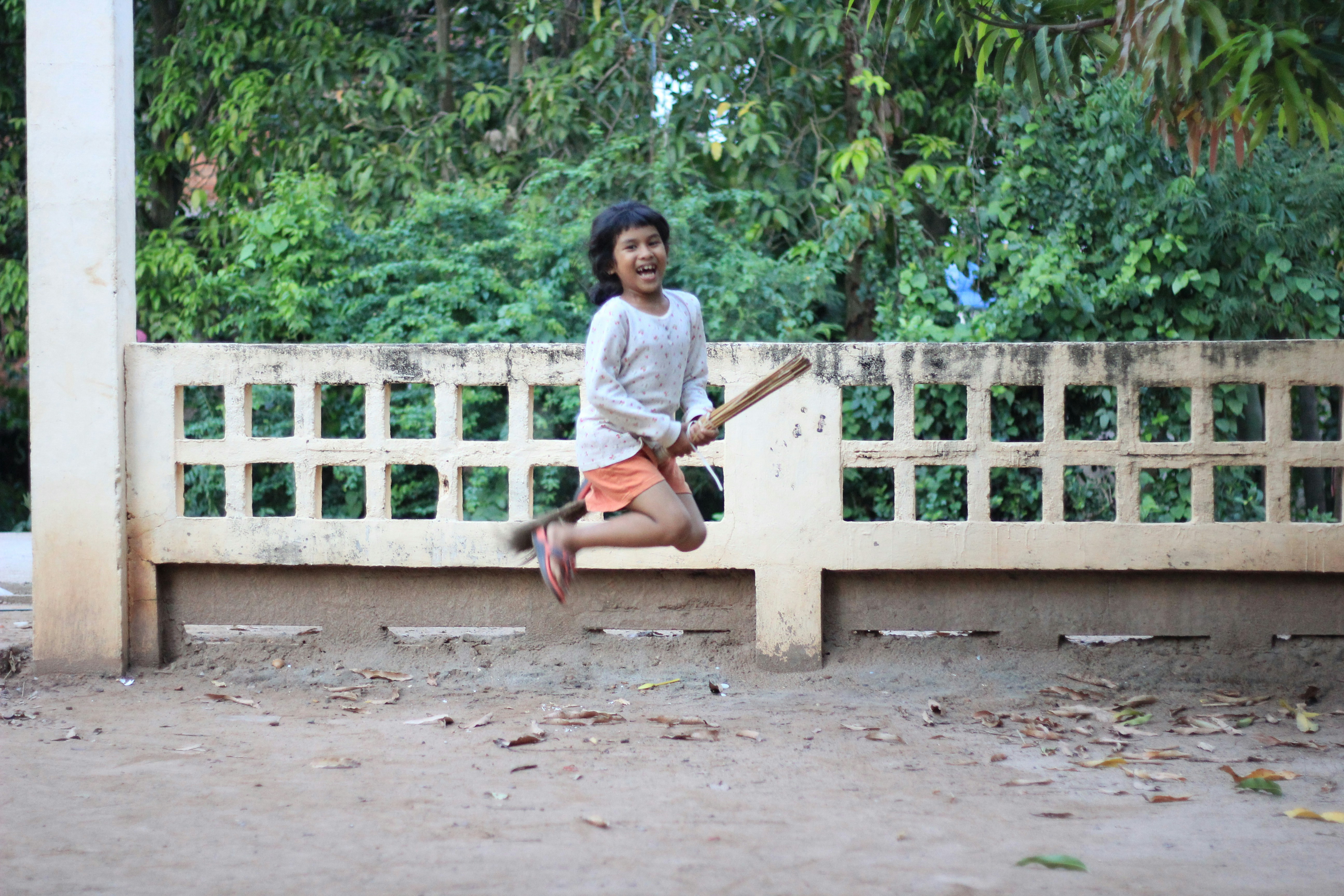 A young girl sitting on a bench with a bat