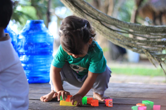 A little girl playing with blocks on the ground