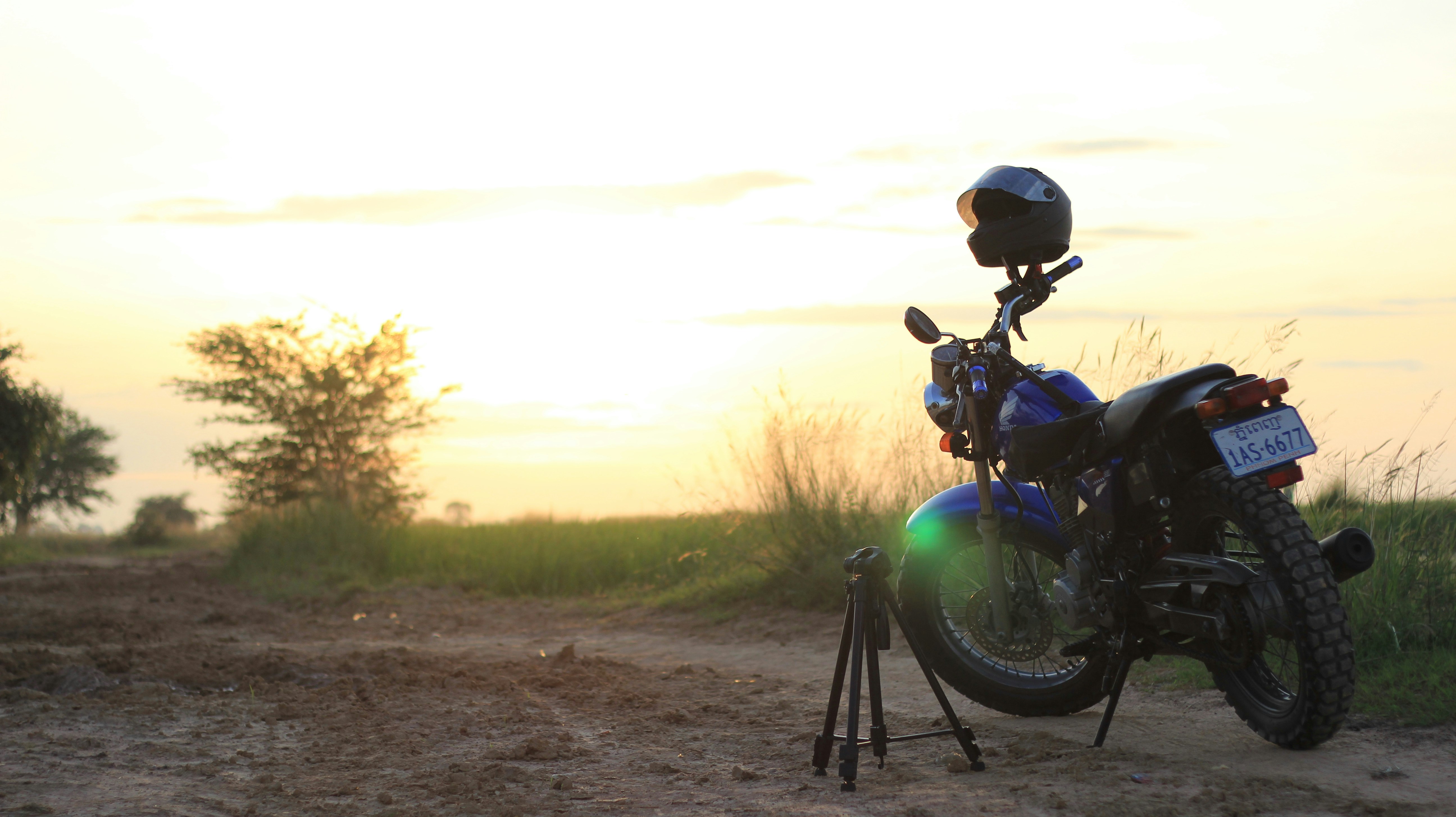 A motorcycle parked on the side of a dirt road