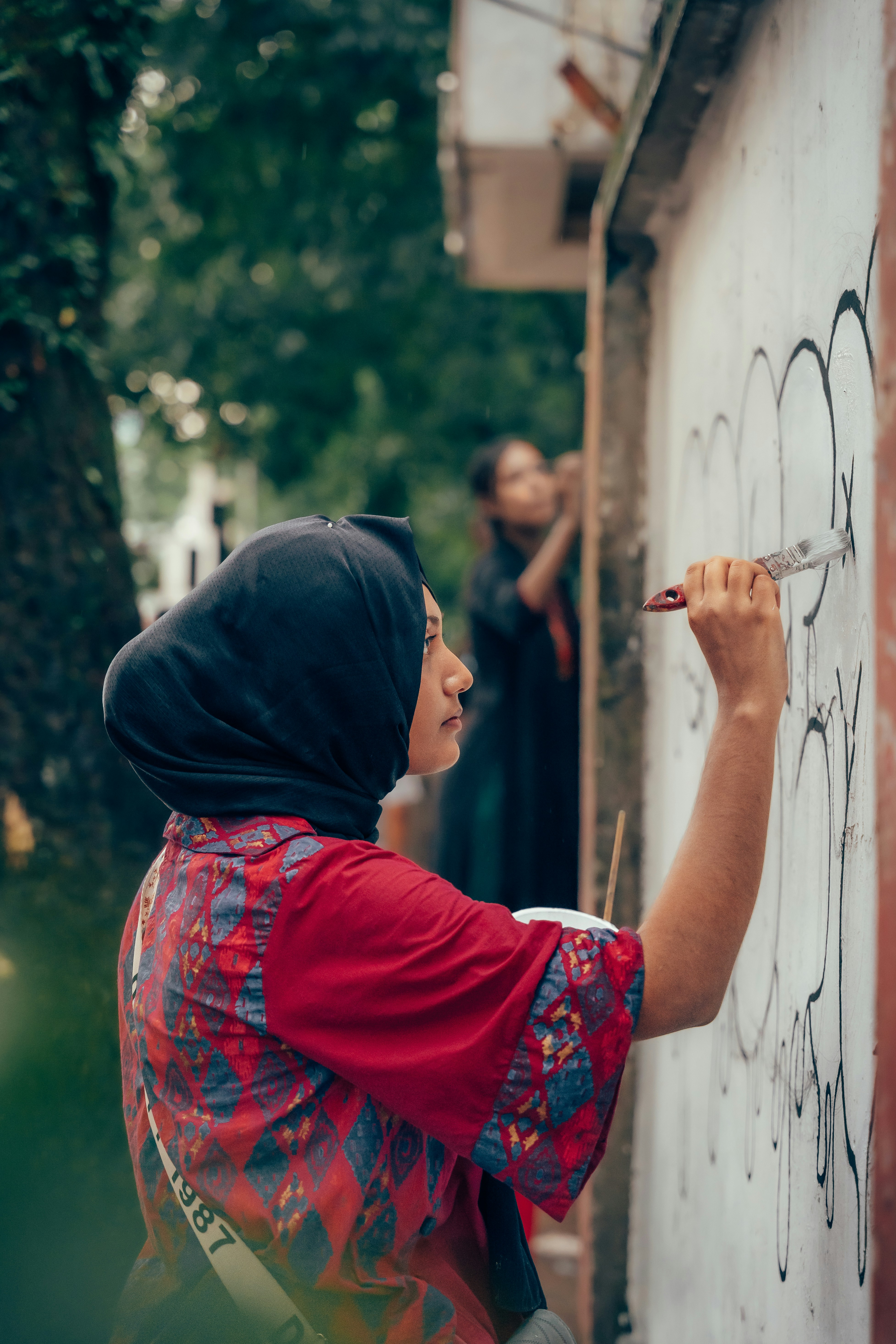 A woman writing on a wall with a marker