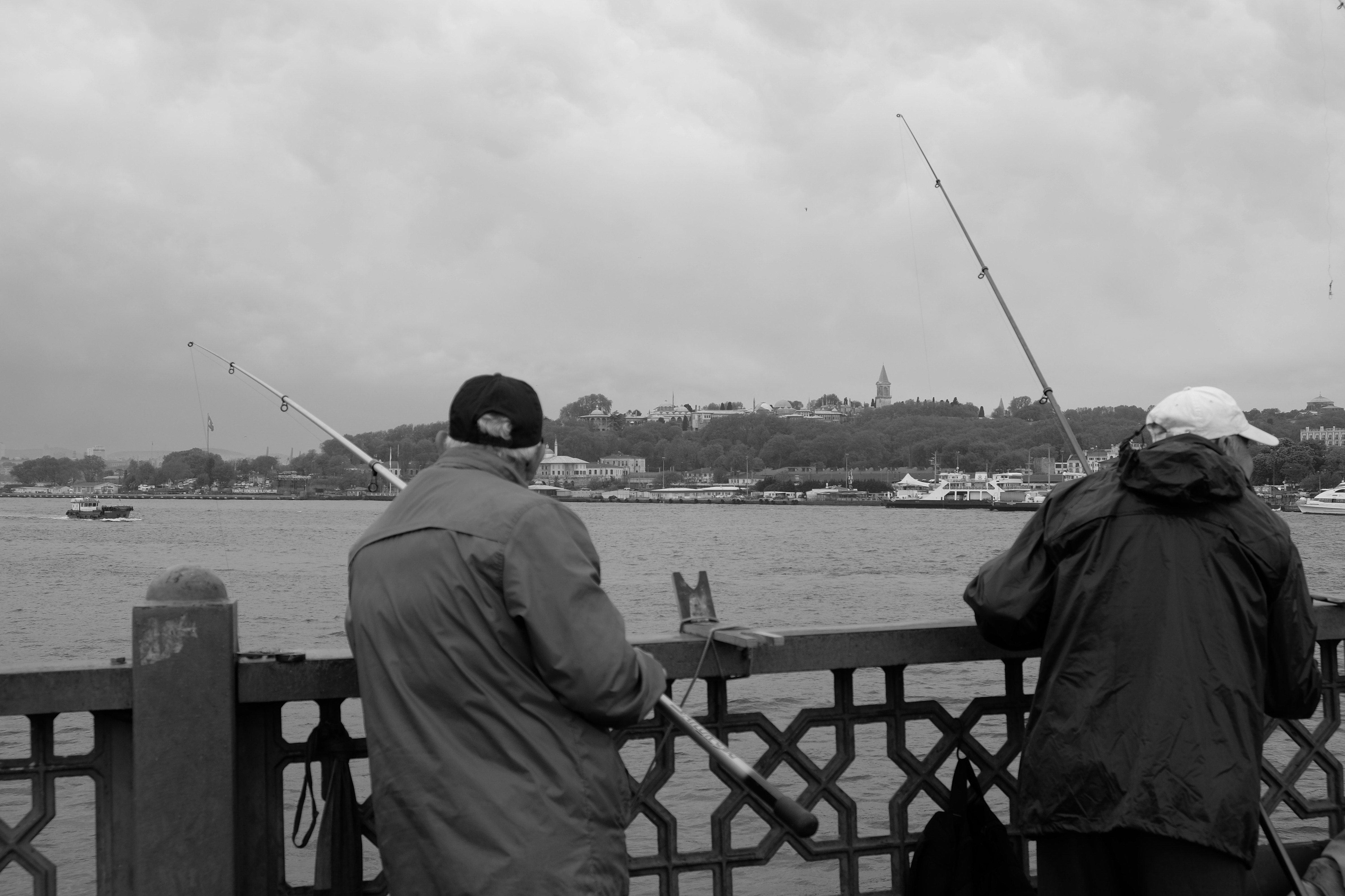 A couple of men standing next to each other on a bridge