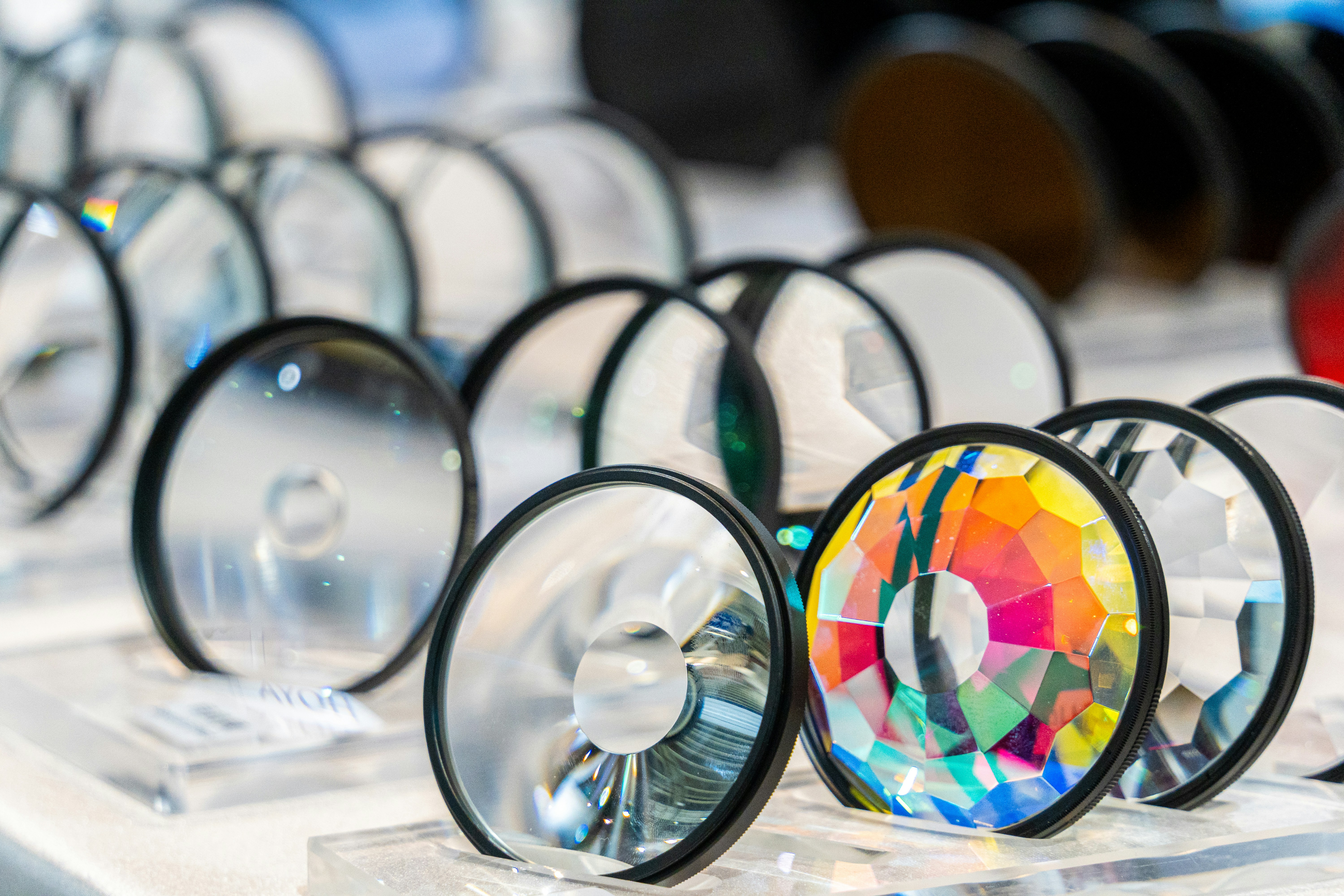 A table topped with lots of different colored glasses