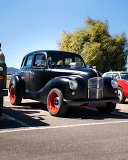 A vintage car is parked in a parking lot
