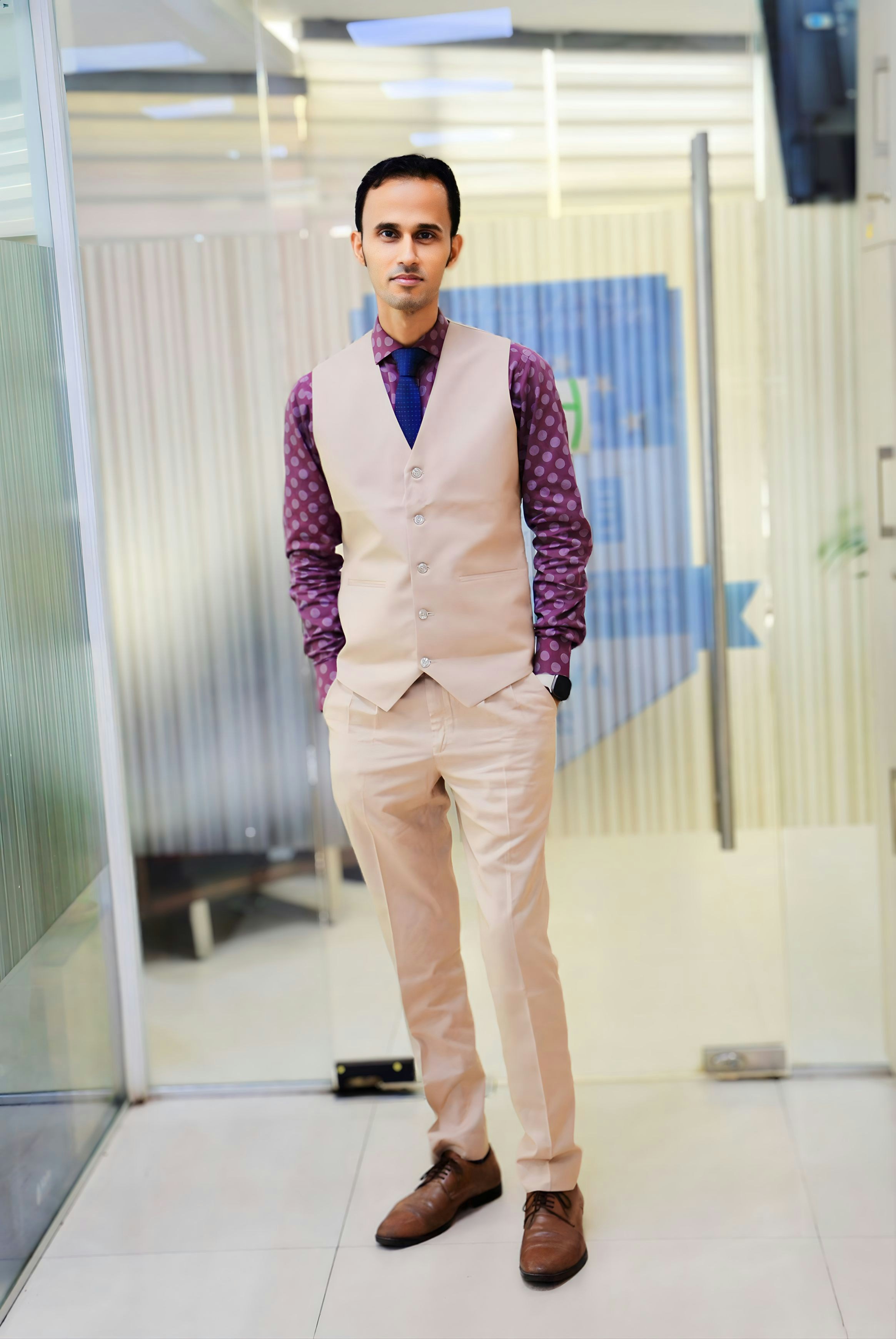 Un homme en gilet et cravate debout dans un couloir