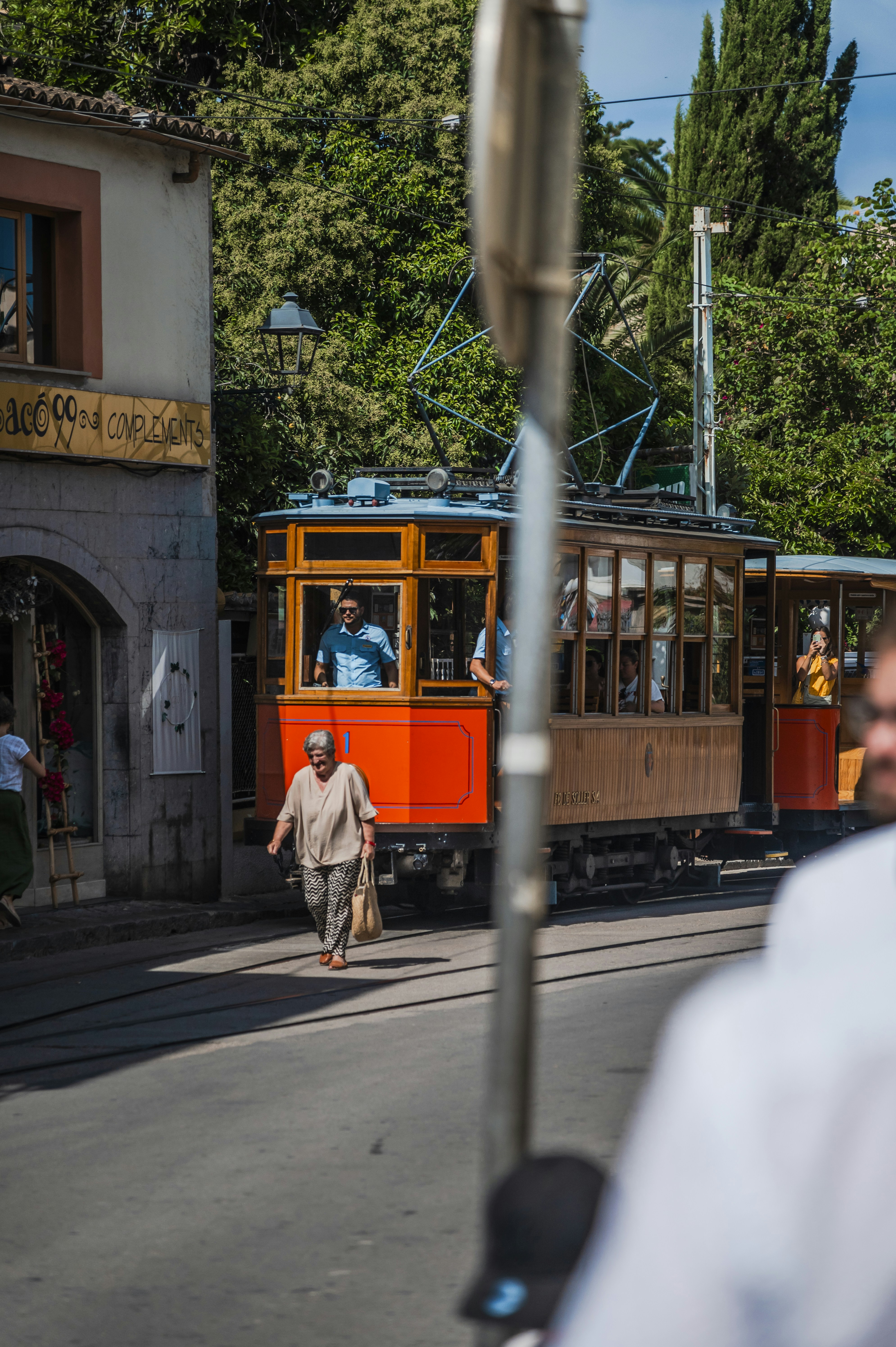 A man walking down a street next to a trolley