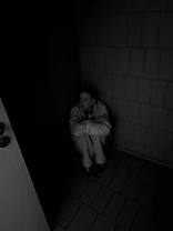 A man sitting on a toilet in a dark room