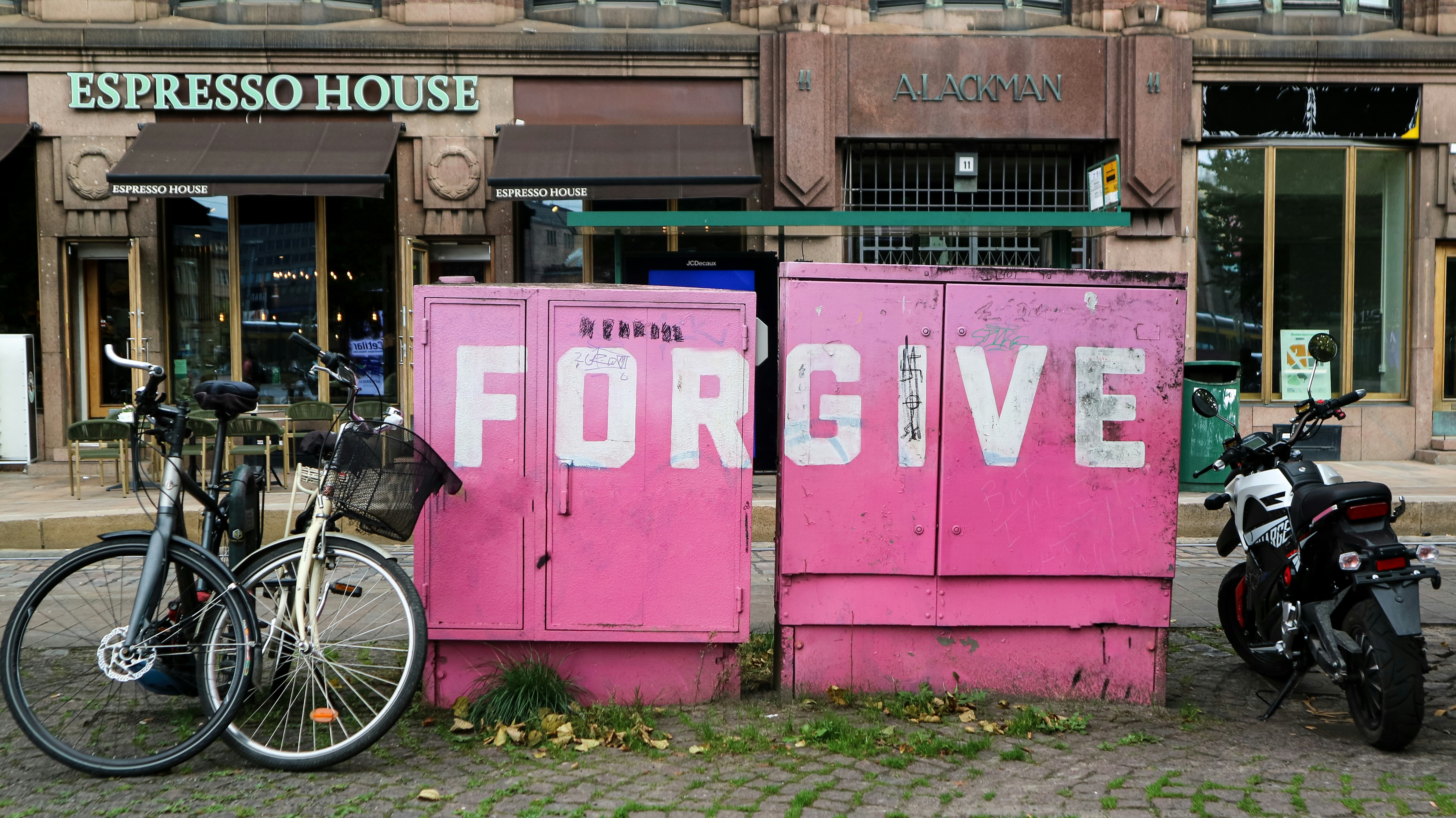 A couple of bikes parked next to a pink box