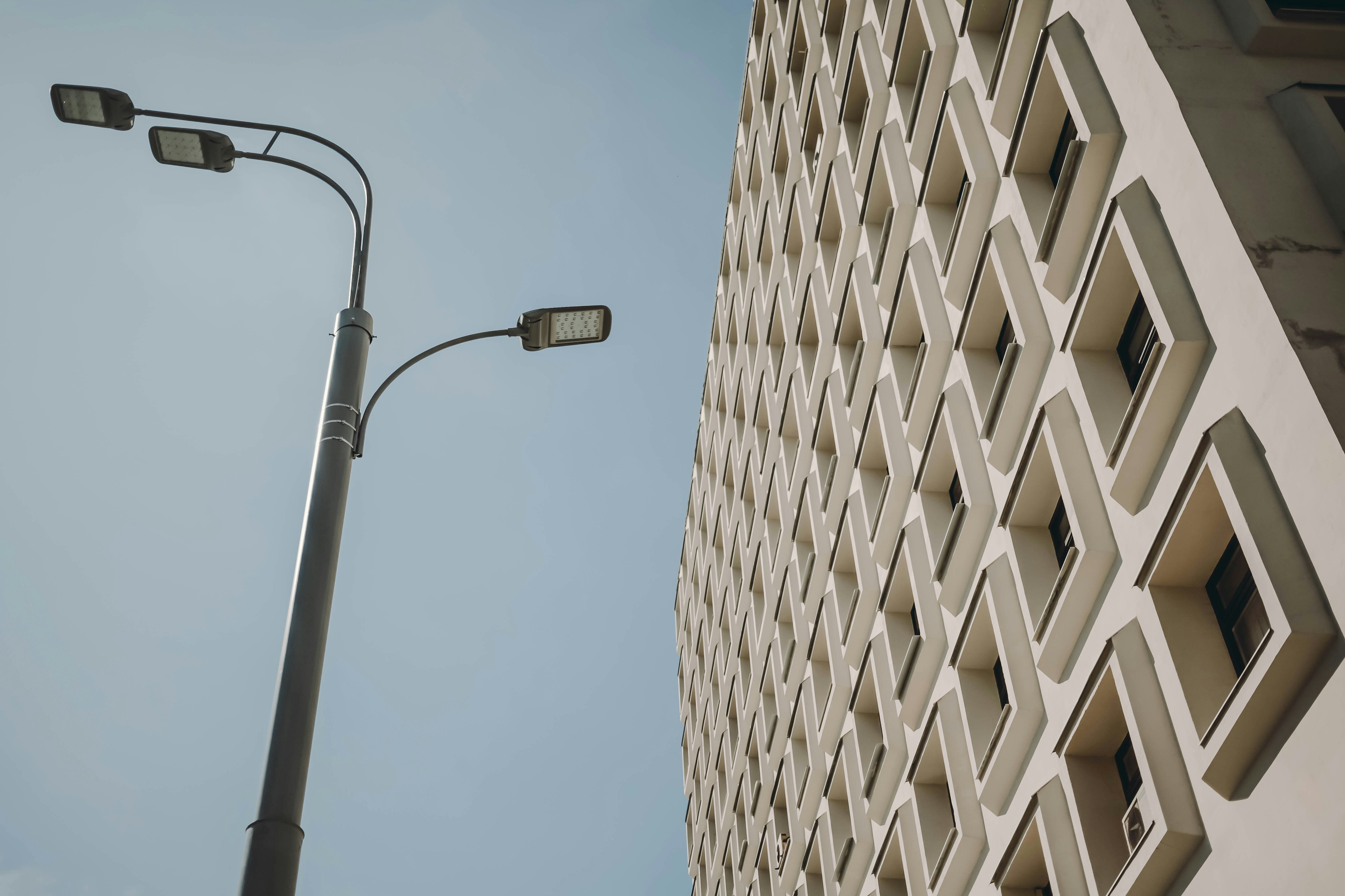 A tall white building next to a street light