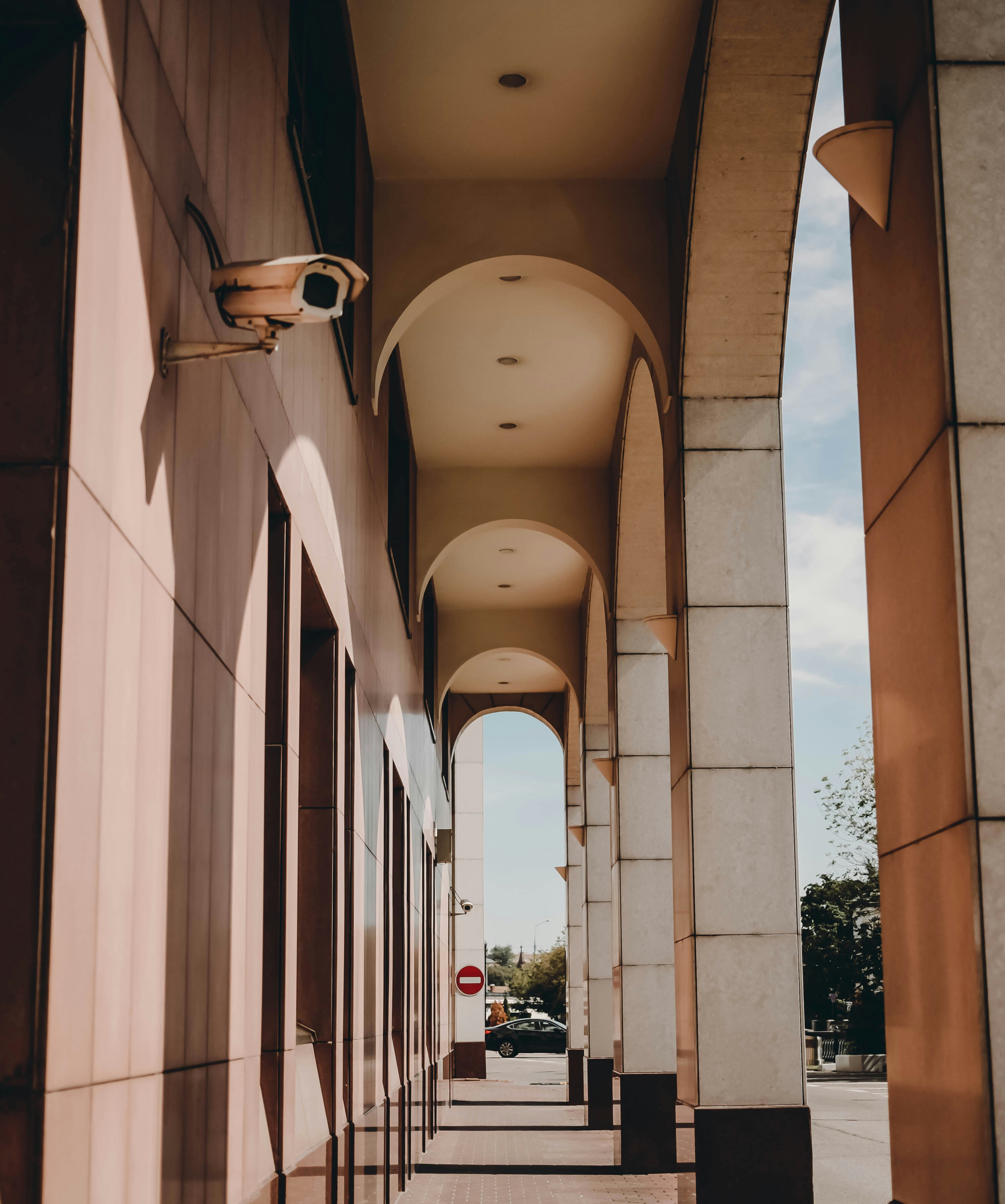 A long hallway between two buildings with a sky background