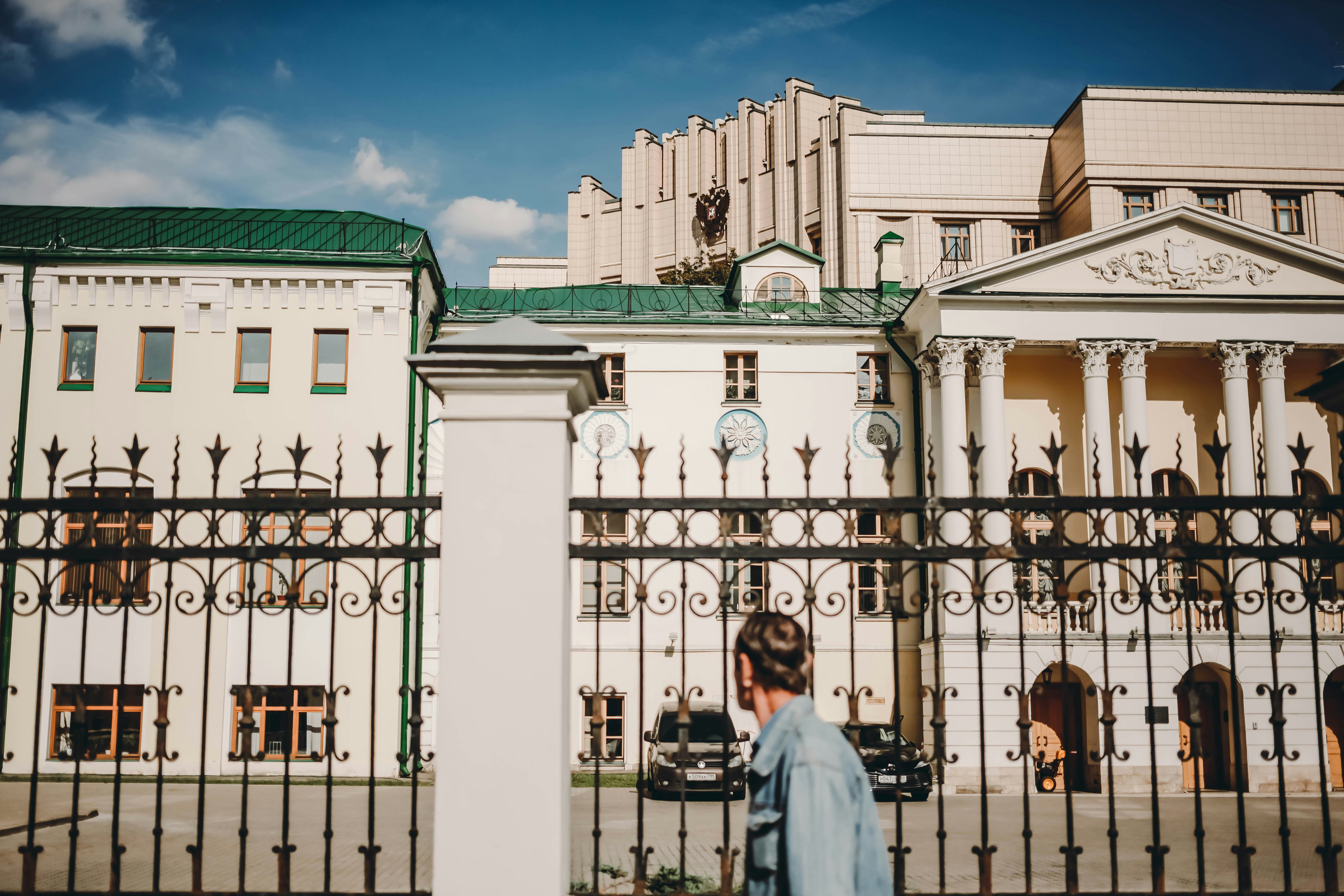 A woman standing in front of a fence in front of a building