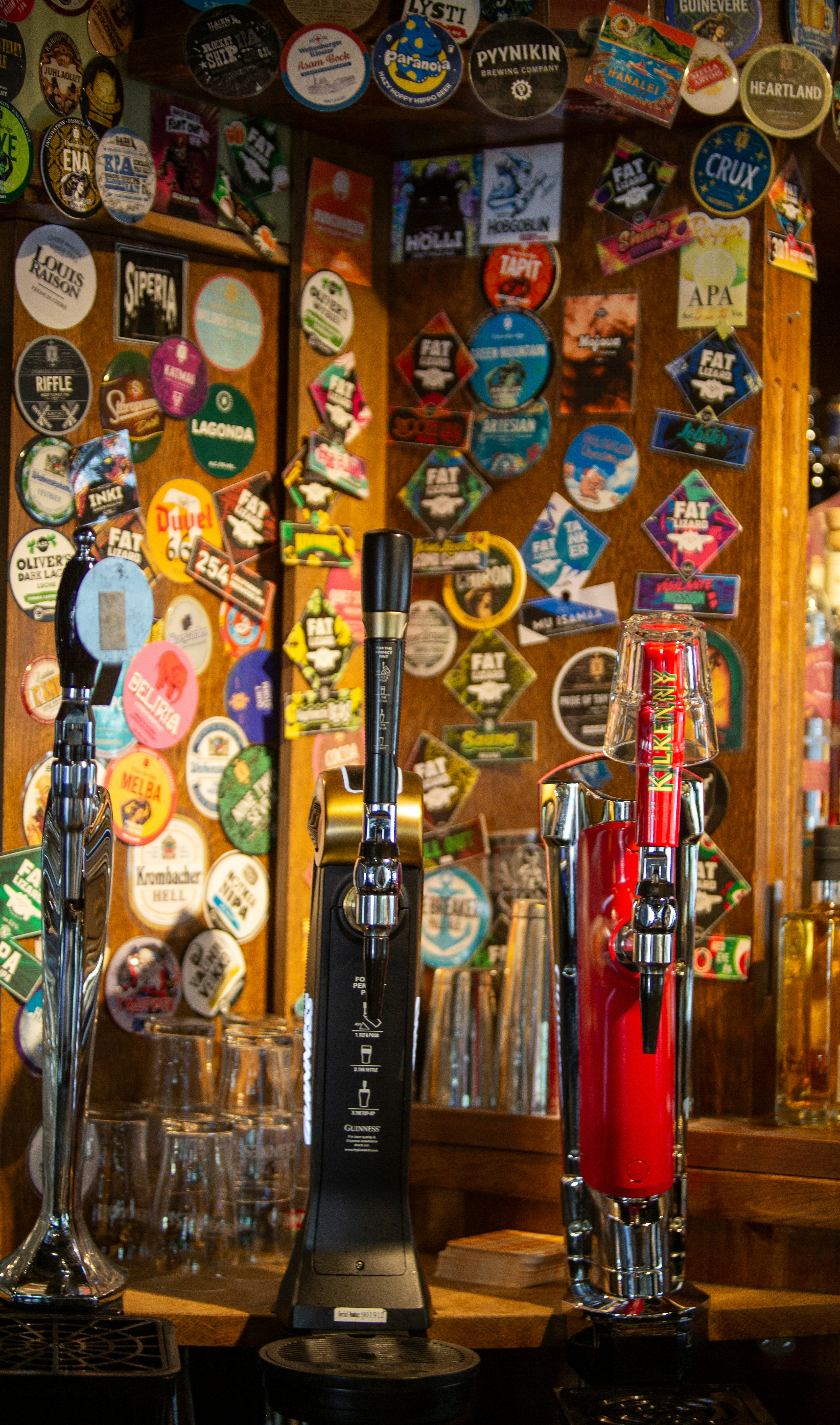 A bar with many different types of beer taps