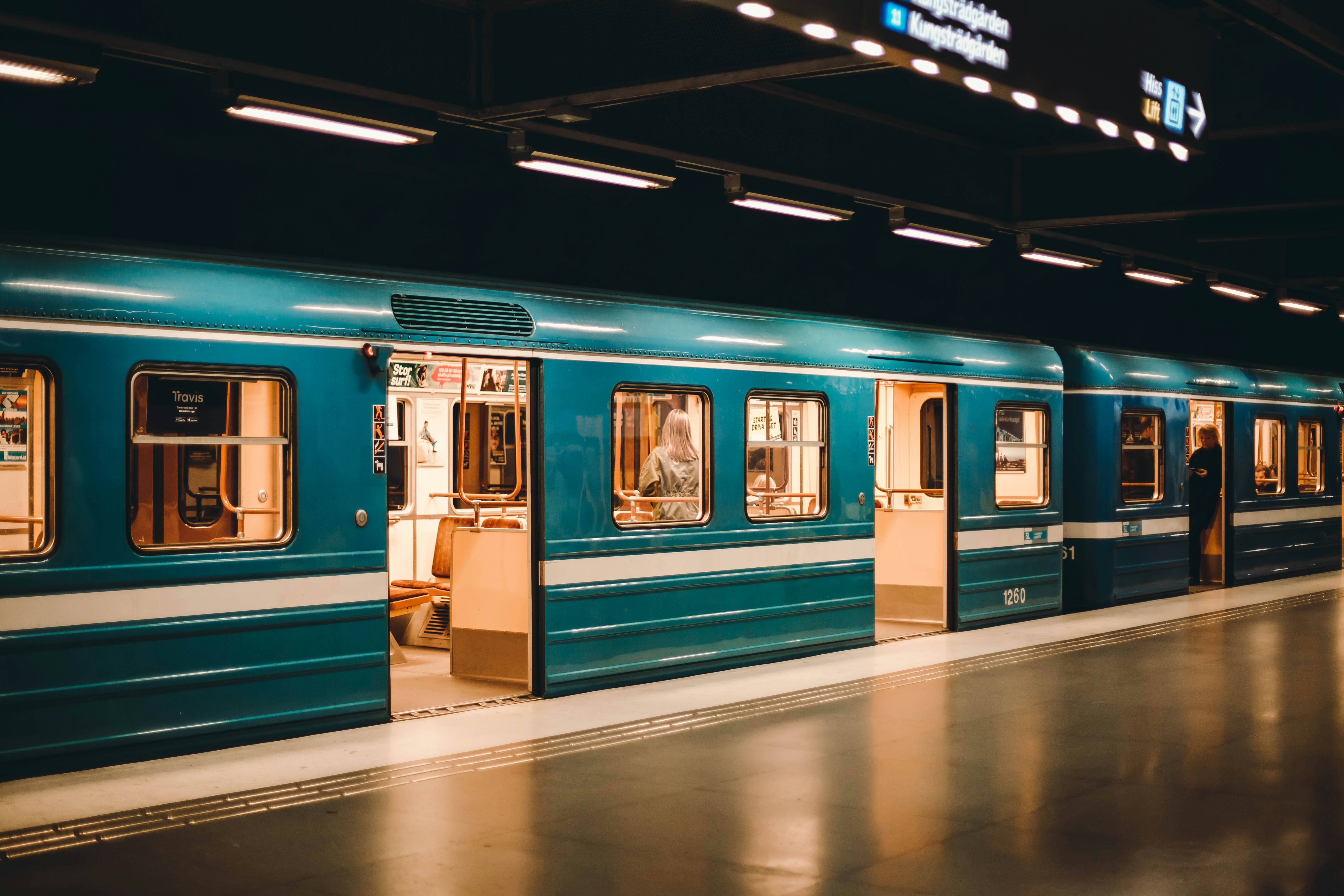 A blue train parked at a train station