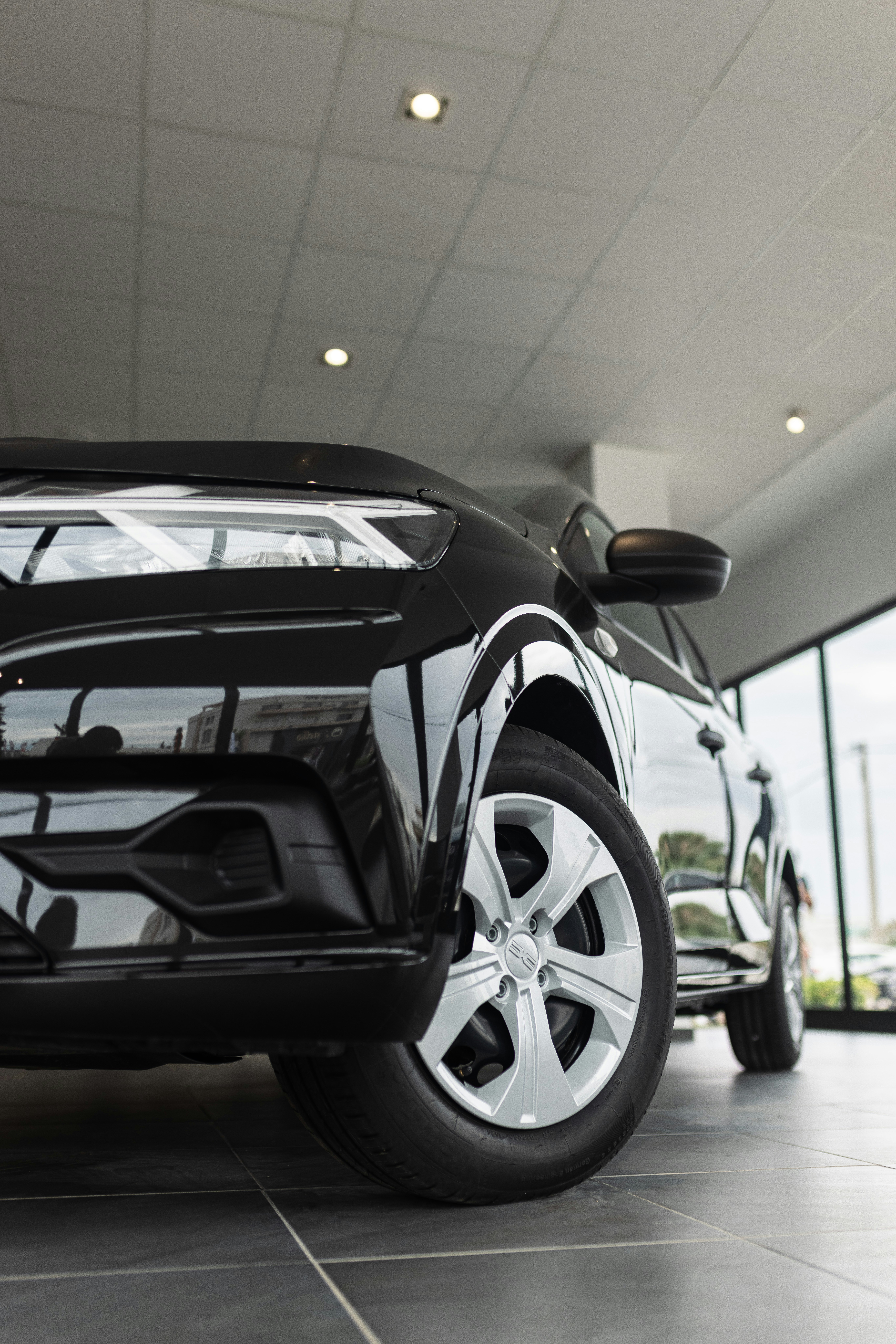 A black car is parked in a showroom