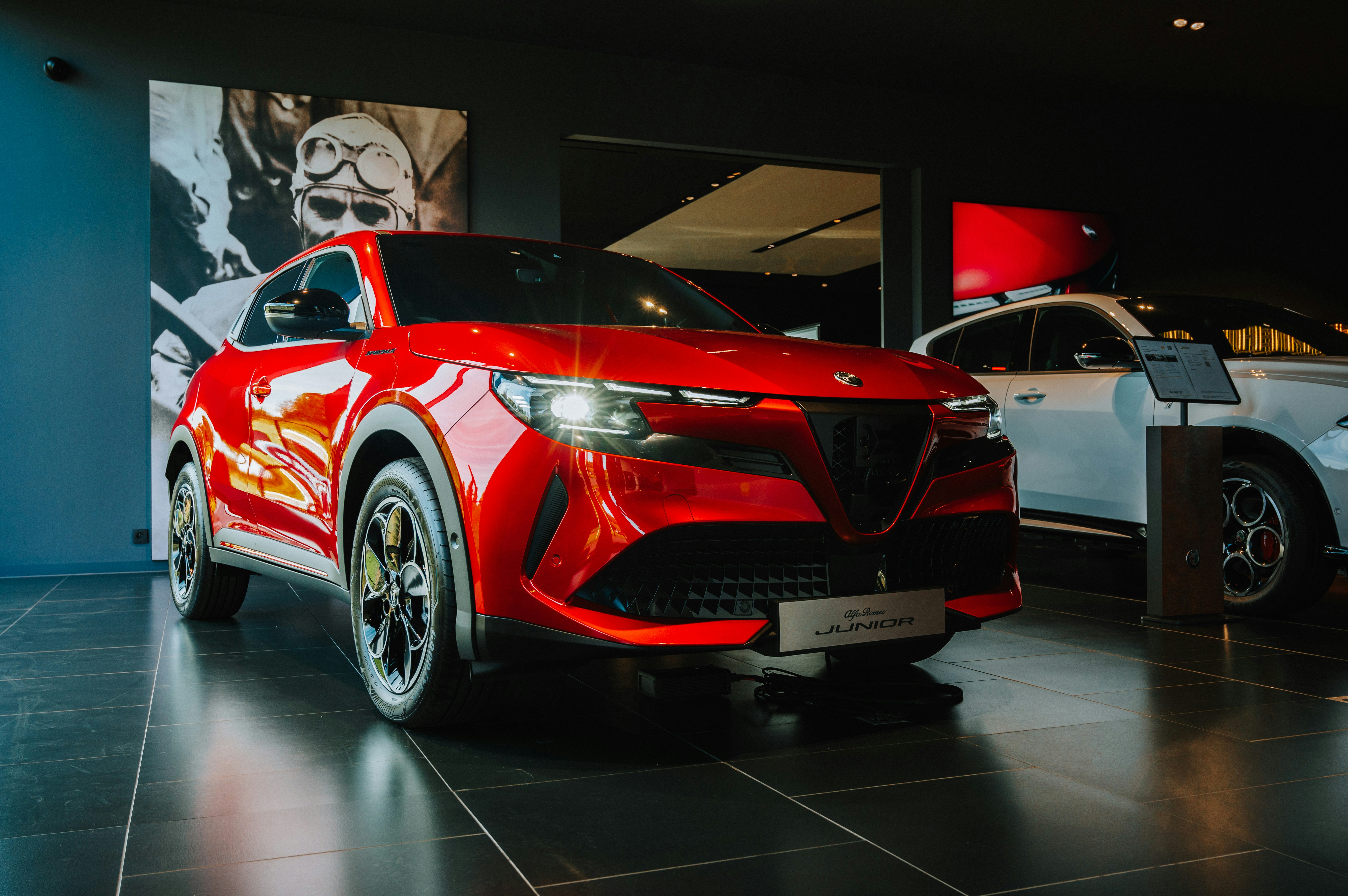A red car is on display in a showroom