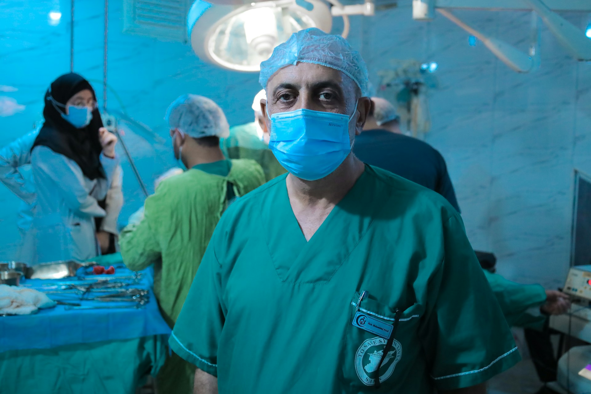 A man wearing a surgical mask standing in a room
