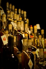 A large amount of bottles of alcohol are stacked on a shelf