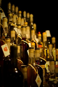 A large amount of bottles of alcohol are stacked on a shelf