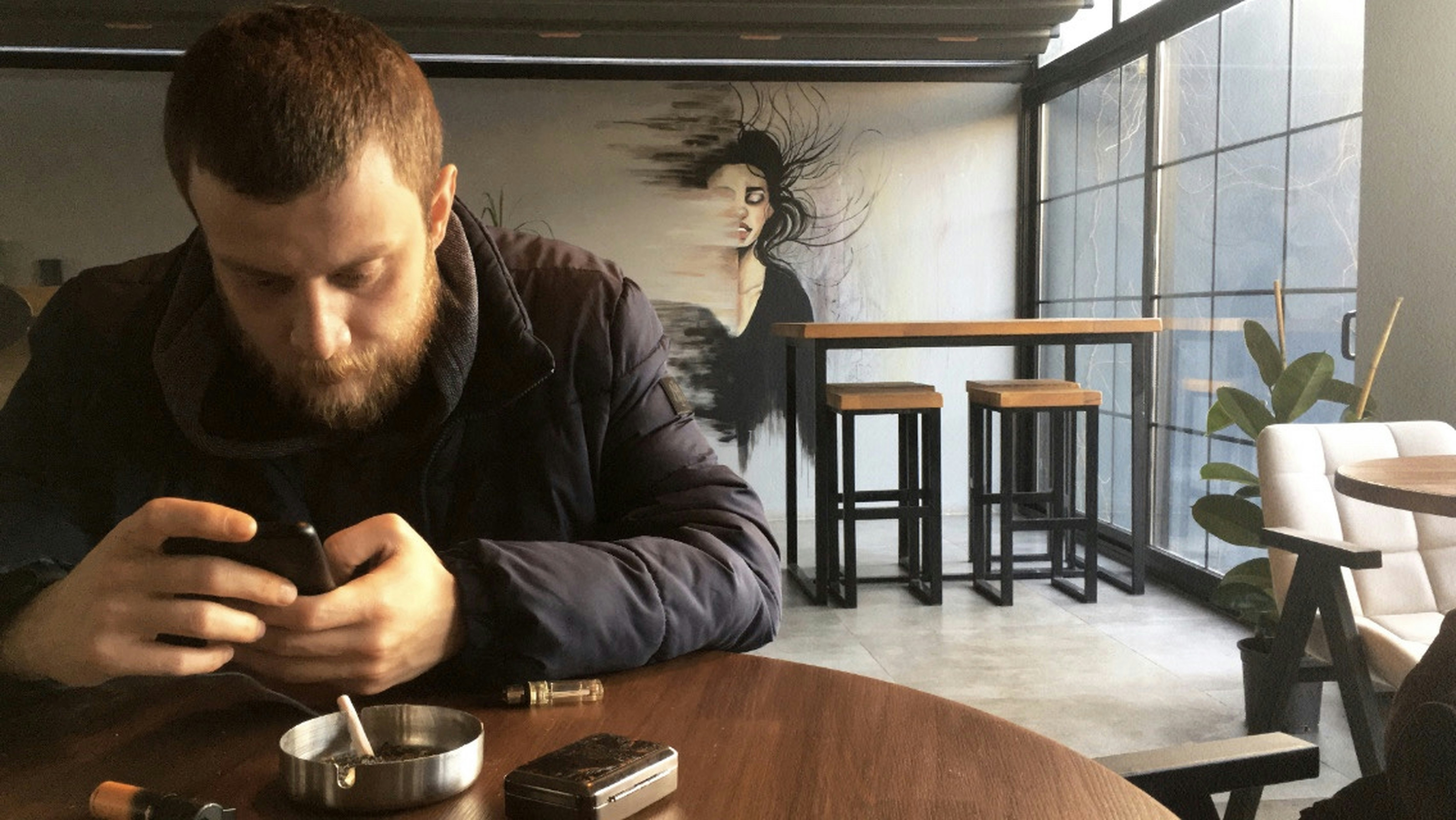 A man sitting at a table looking at his cell phone