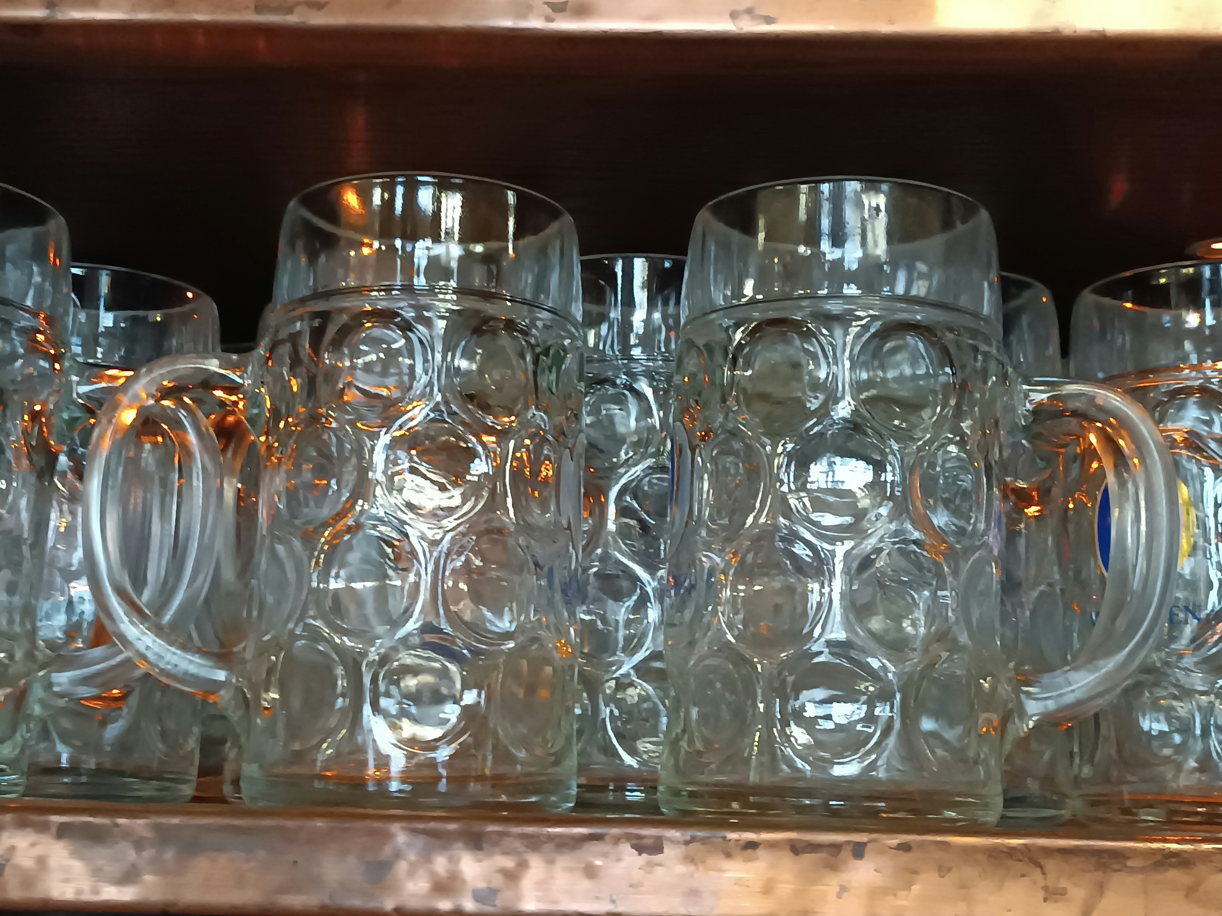 A bunch of glasses are lined up on a shelf