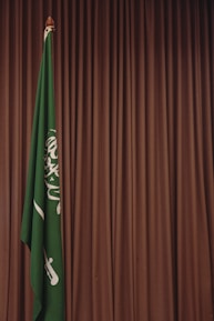 A green and white flag and a brown curtain