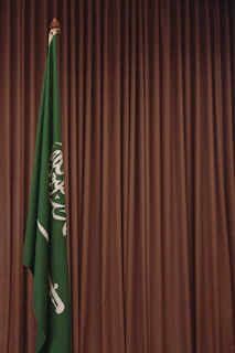 A green and white flag and a brown curtain