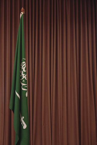 A green and white flag and a brown curtain