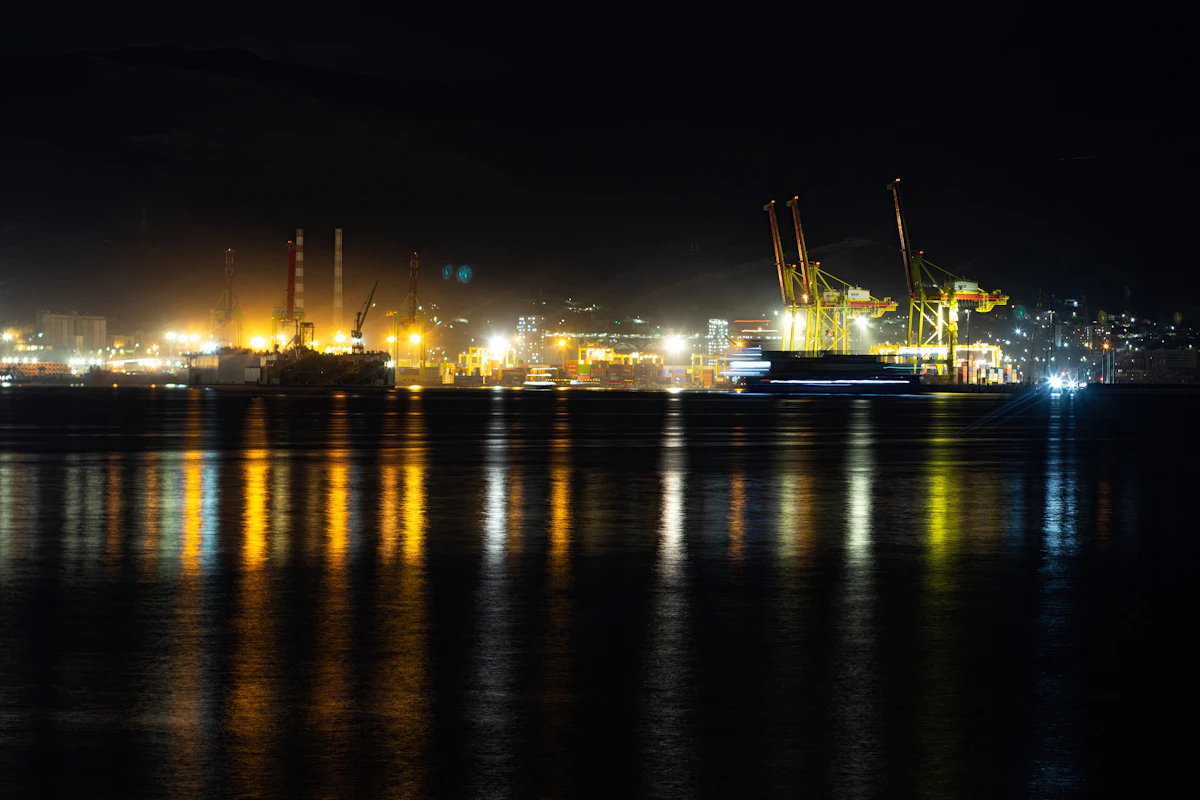 A large cruise ship berthed at a pier lit up after dark