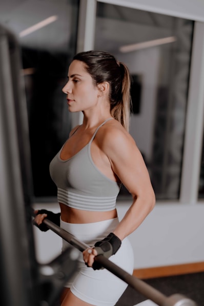 A woman in a sports bra top holding a bar