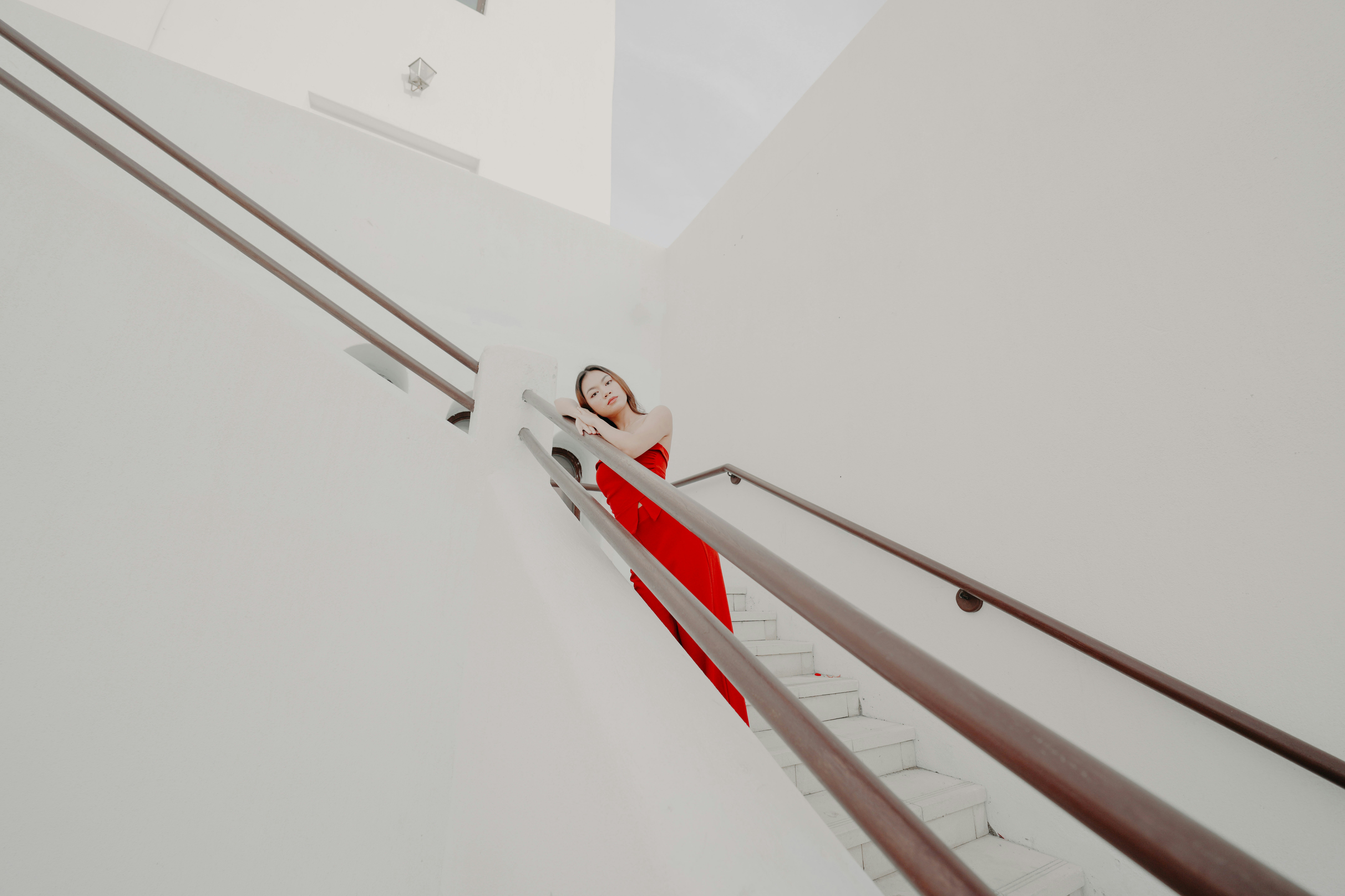 A woman in a red dress walking up a set of stairs