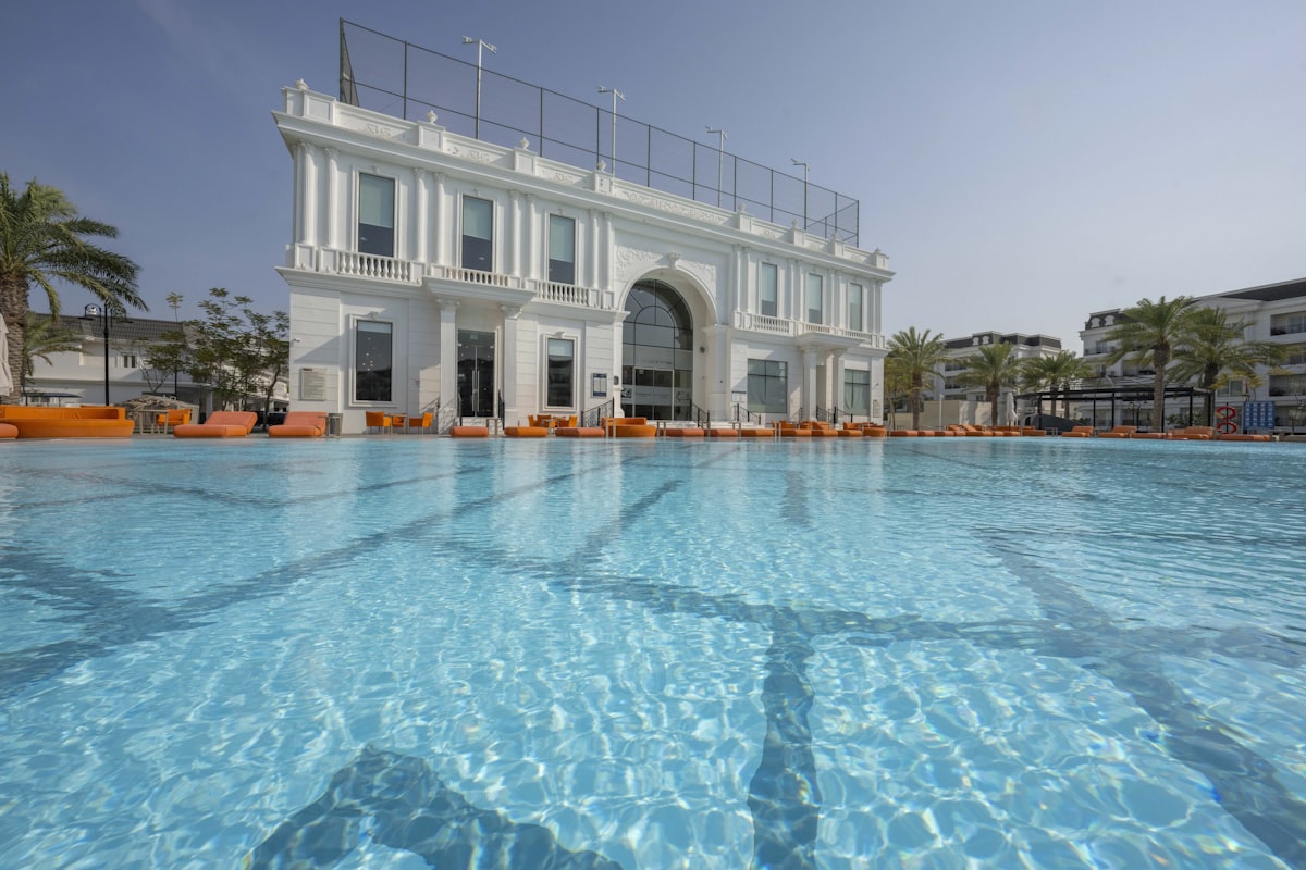 A large swimming pool in front of a white building