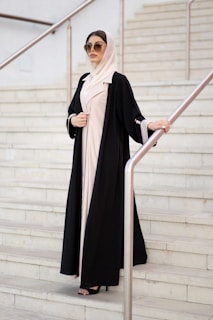 A woman in a black and white outfit is standing on a set of stairs