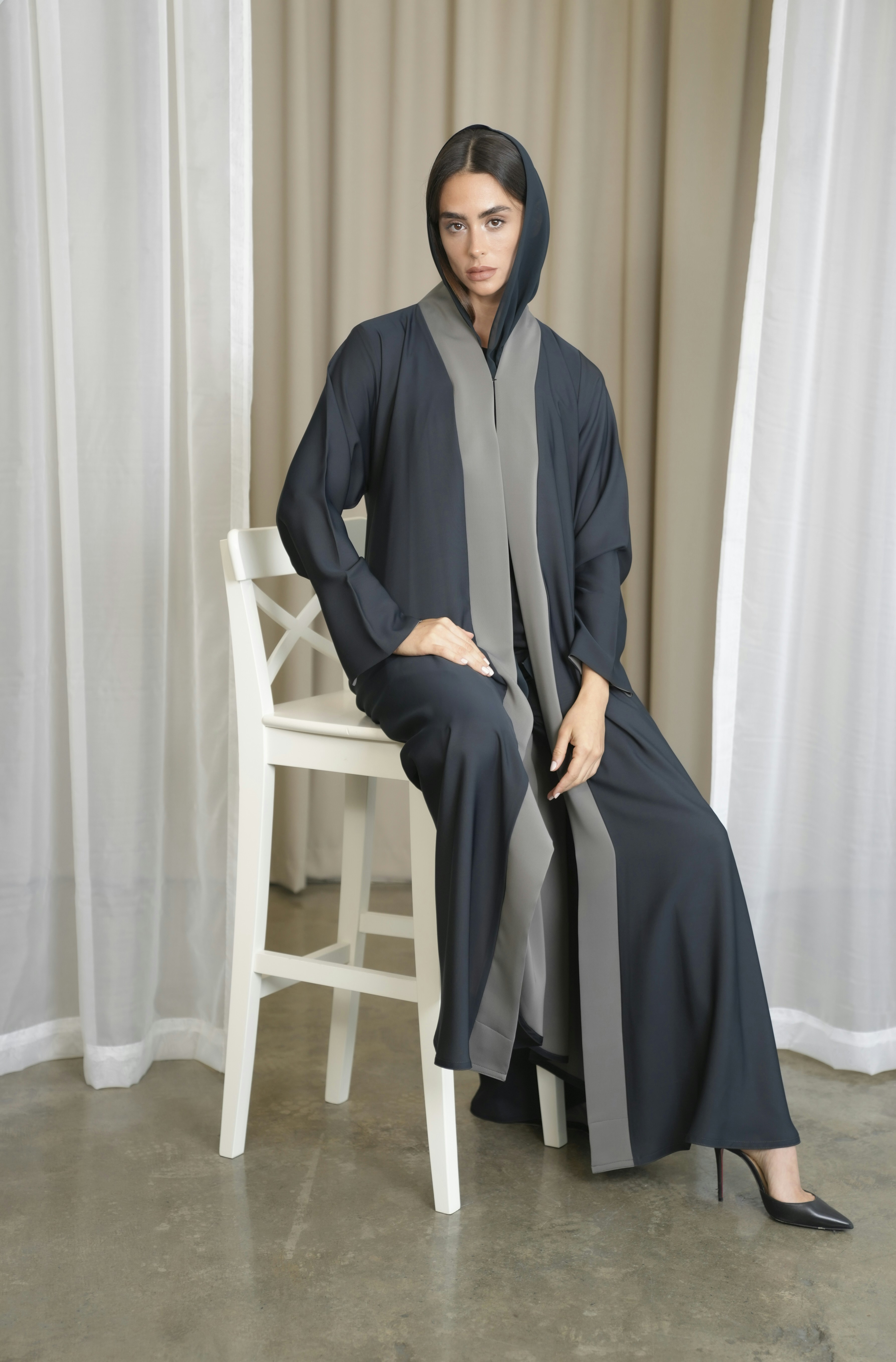 A woman is sitting on a chair wearing a robe