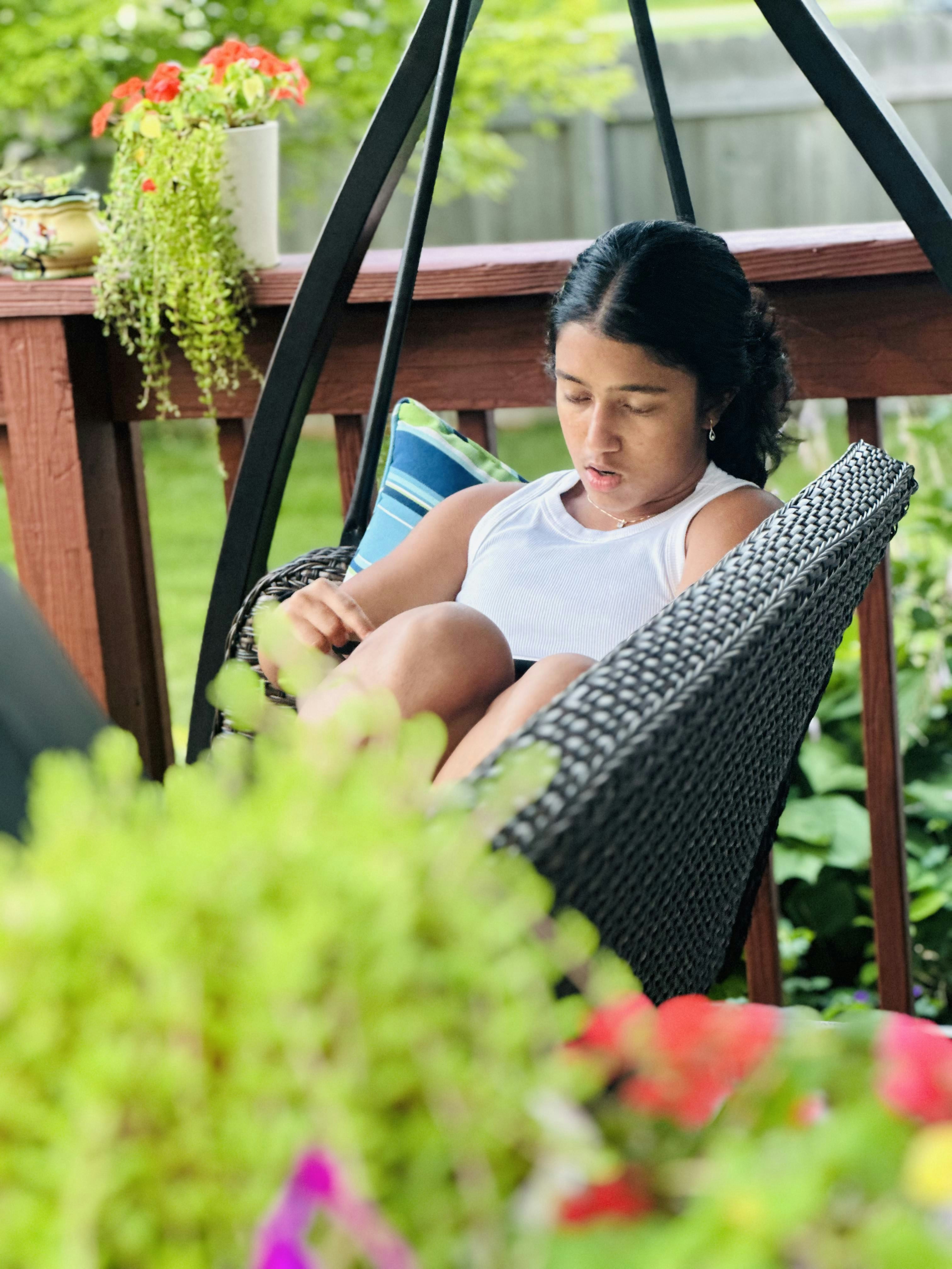 Una mujer sentada en una hamaca leyendo un libro