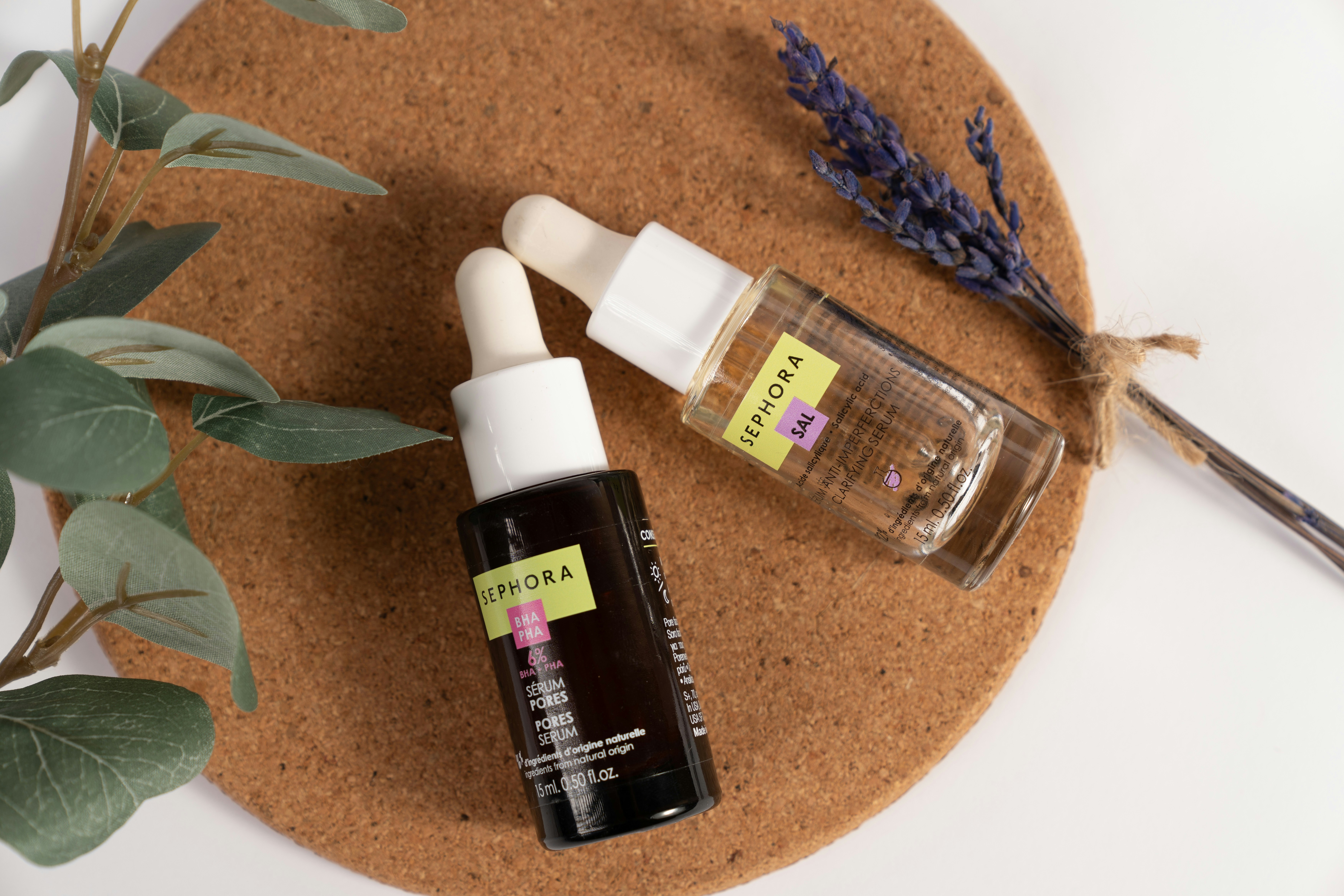 A bottle of essential oils next to a bottle of lavender