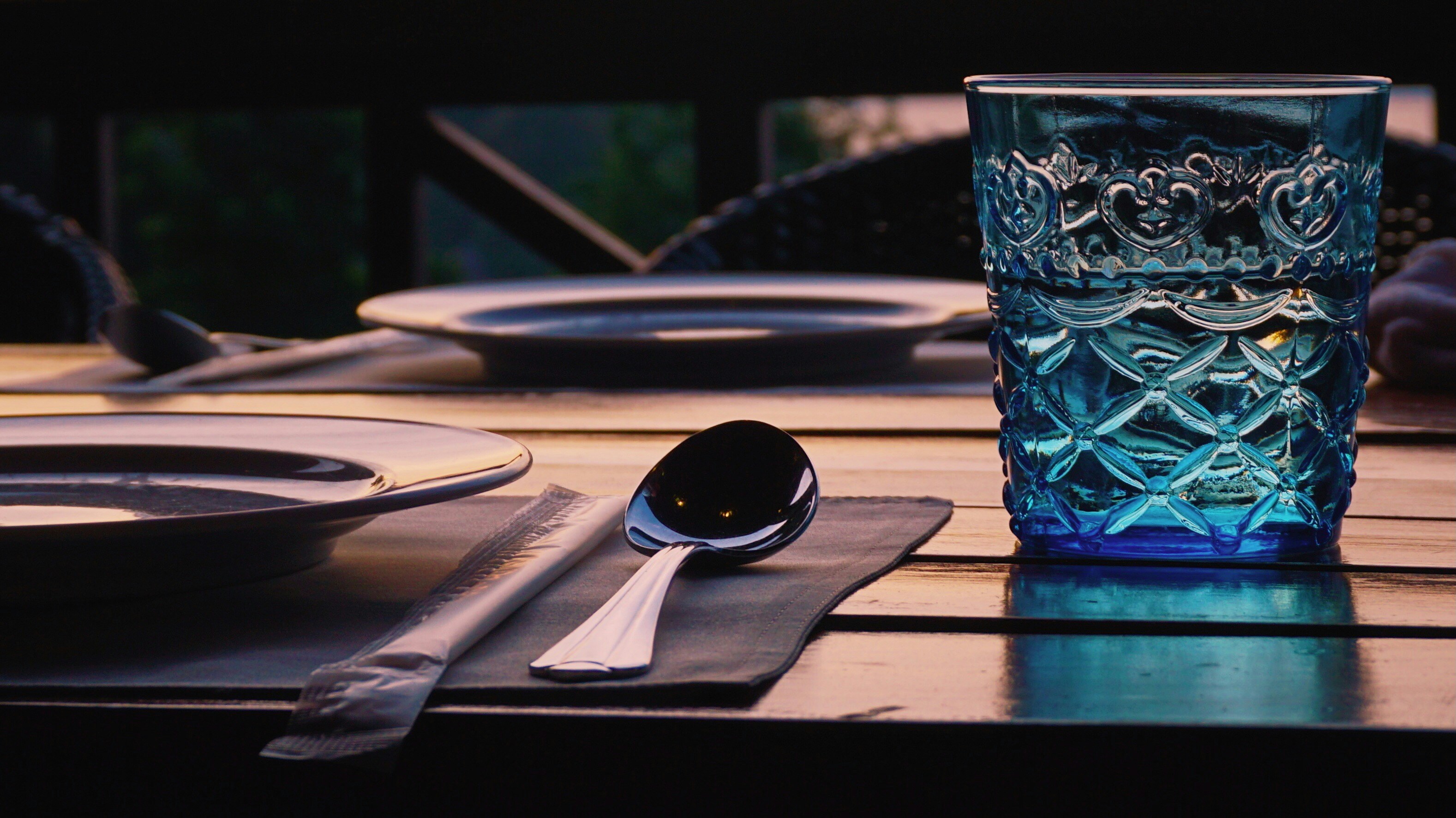 A blue glass sitting on top of a wooden table