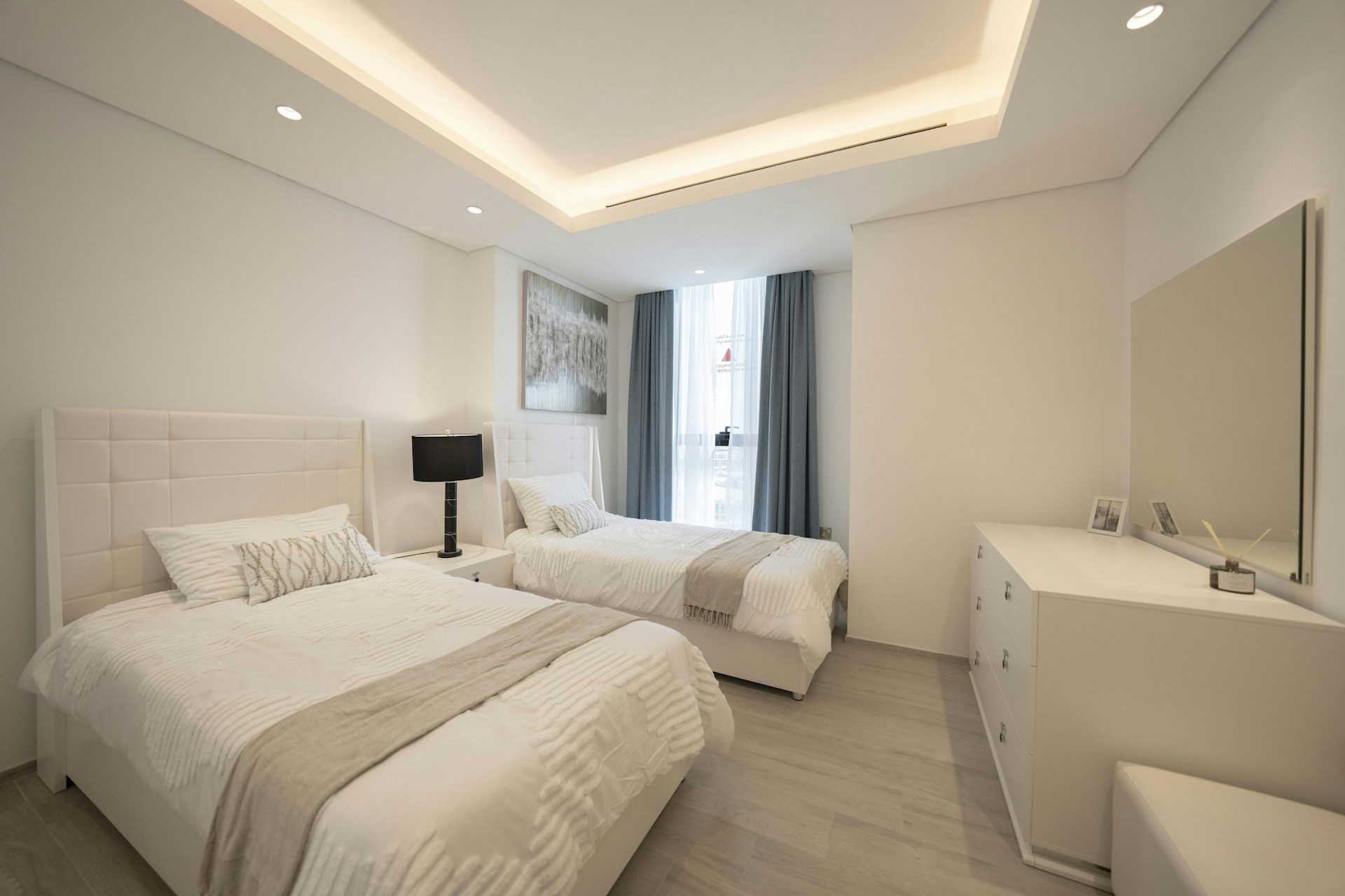 A bedroom with two beds and a desk