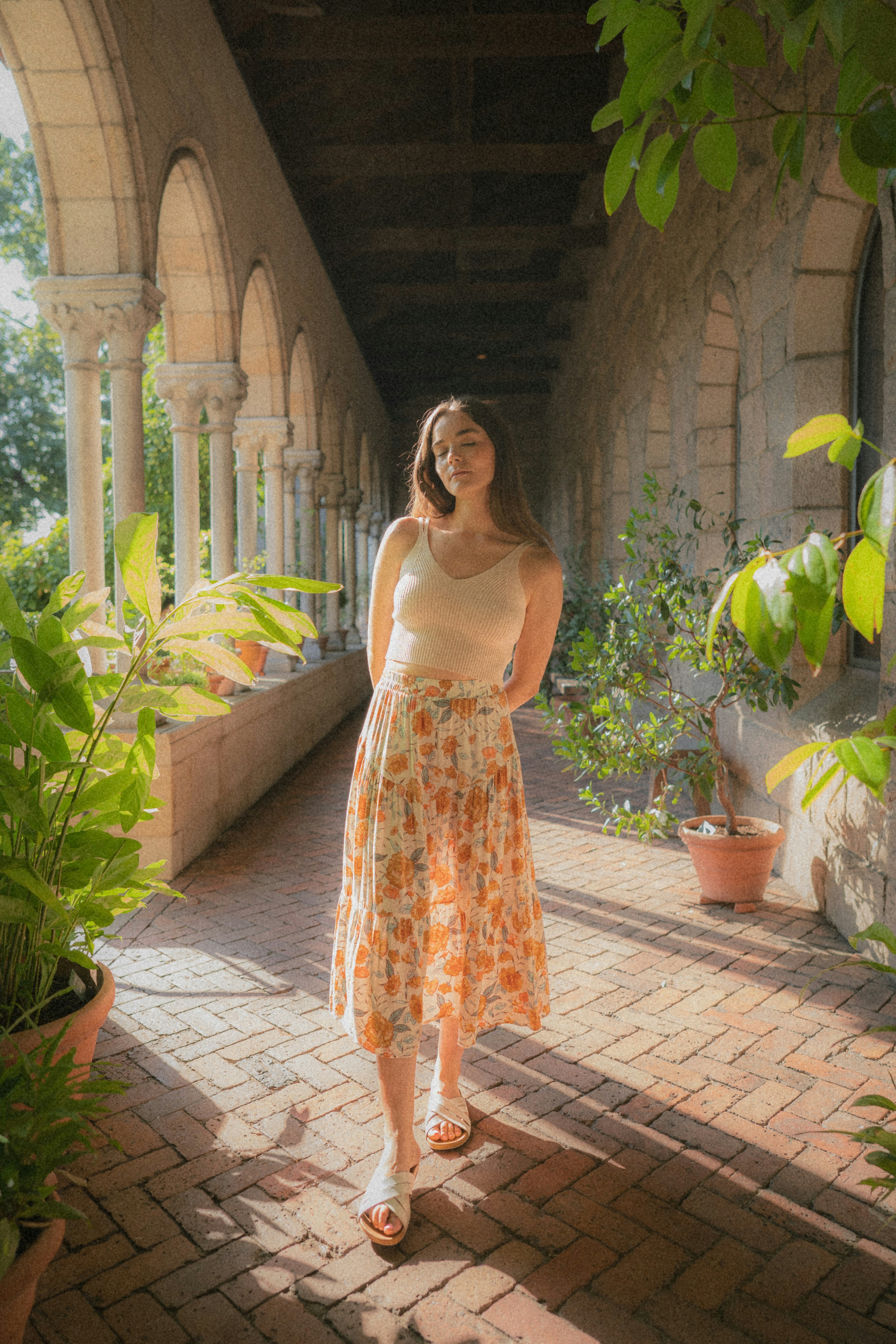 A woman in a dress standing on a brick walkway