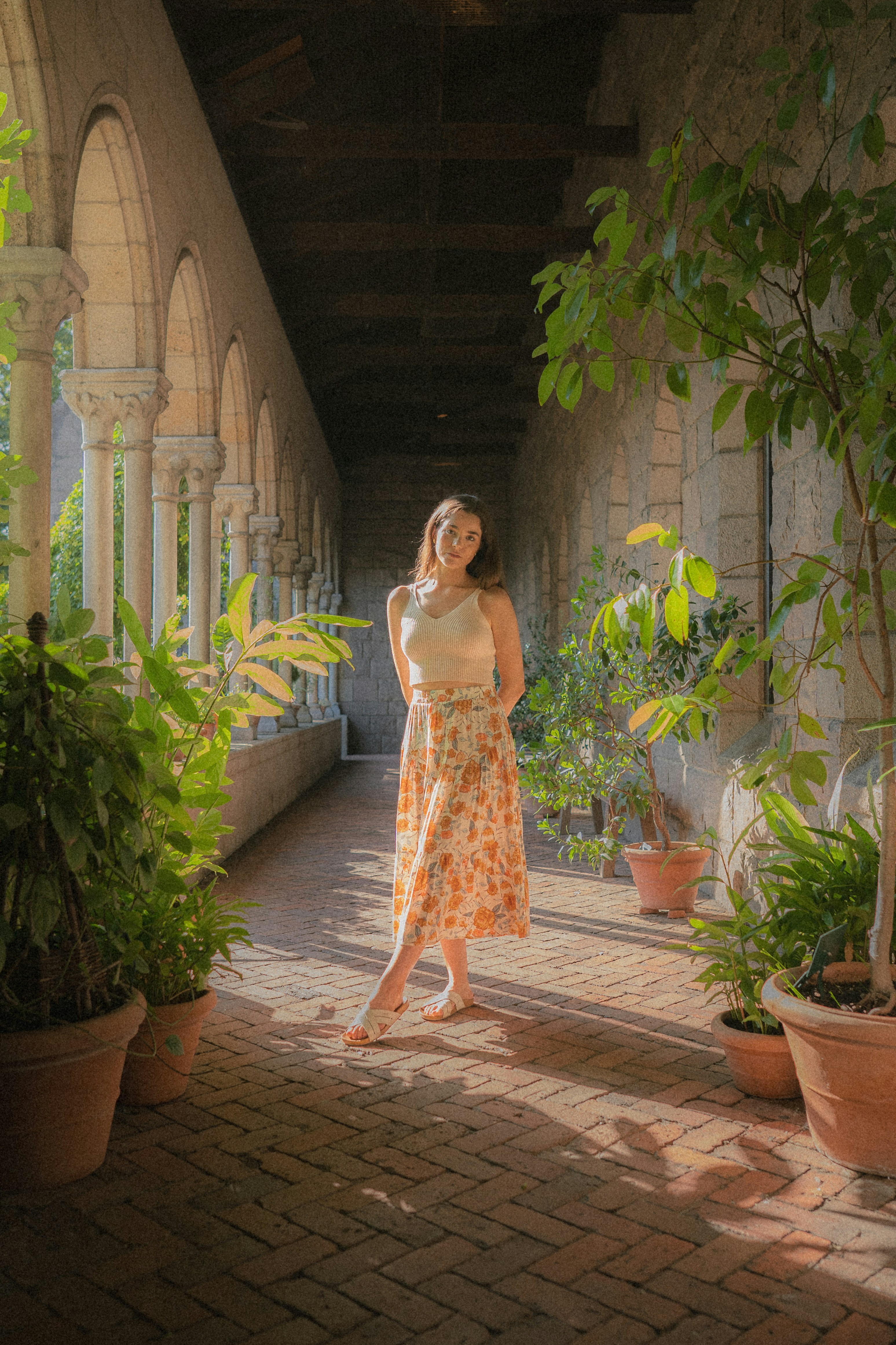 A woman in a dress standing on a brick walkway