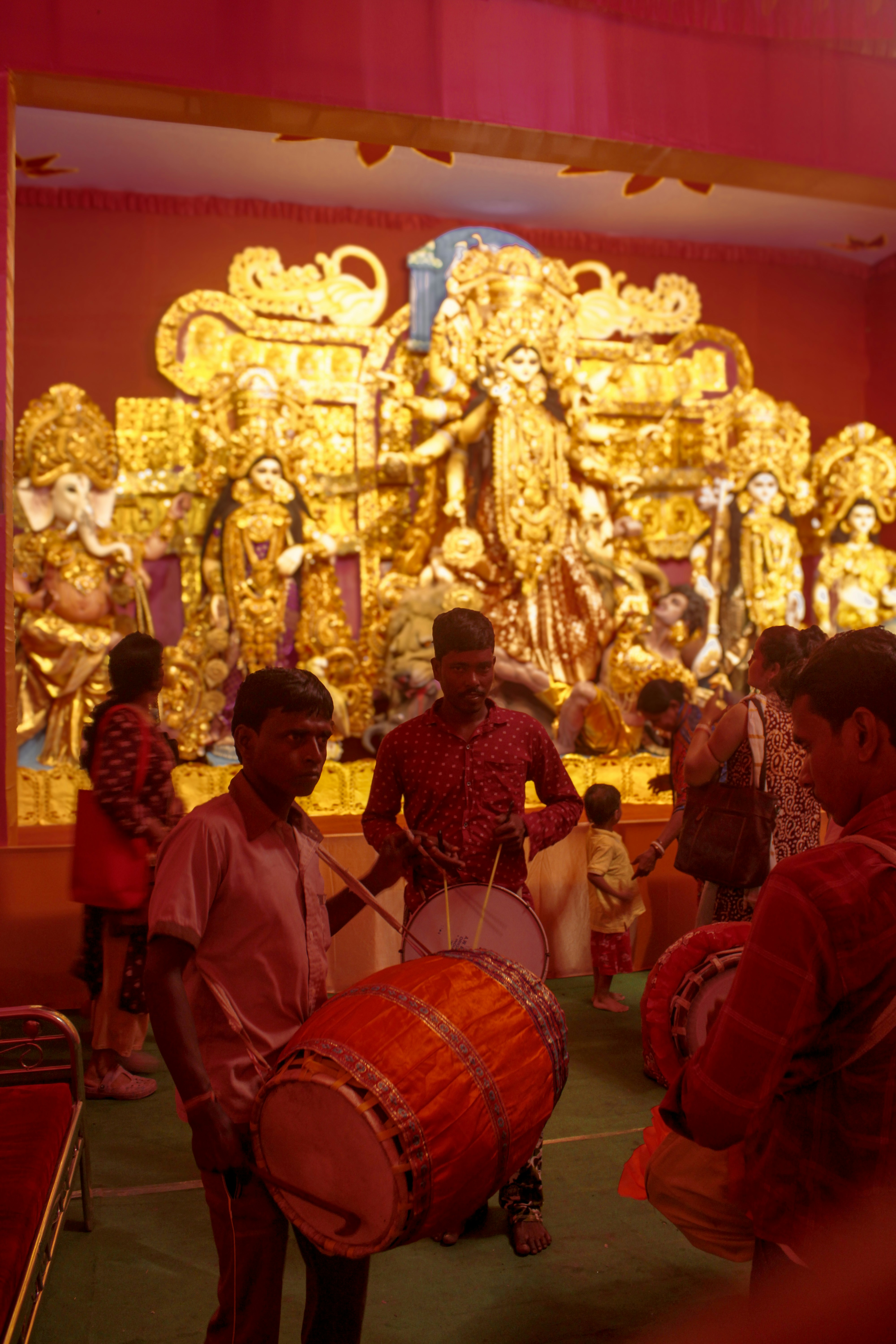 A group of young men playing drums in front of a statue