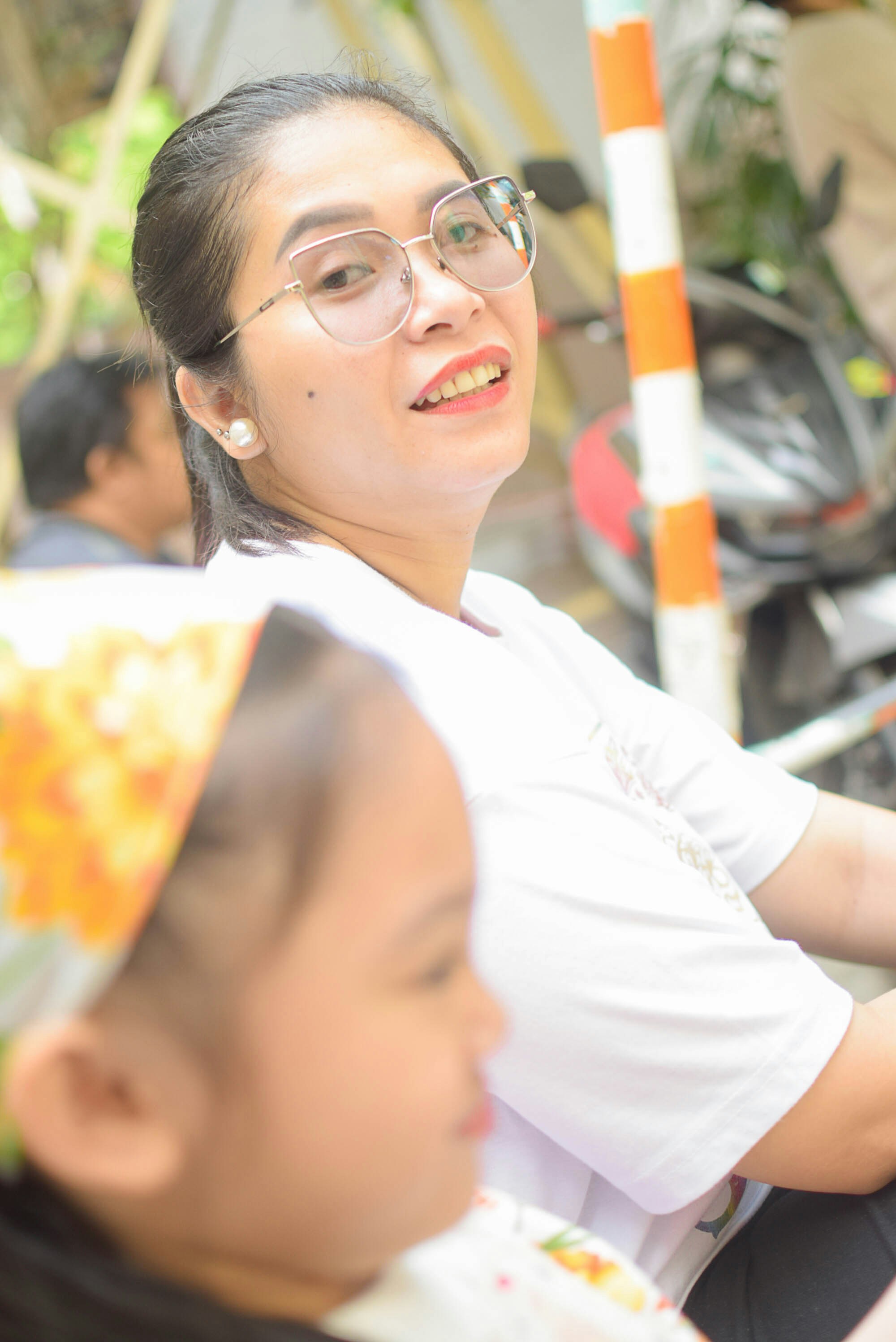 A woman sitting next to a little girl on a motorcycle