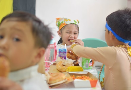 A group of children sitting around a table eating food