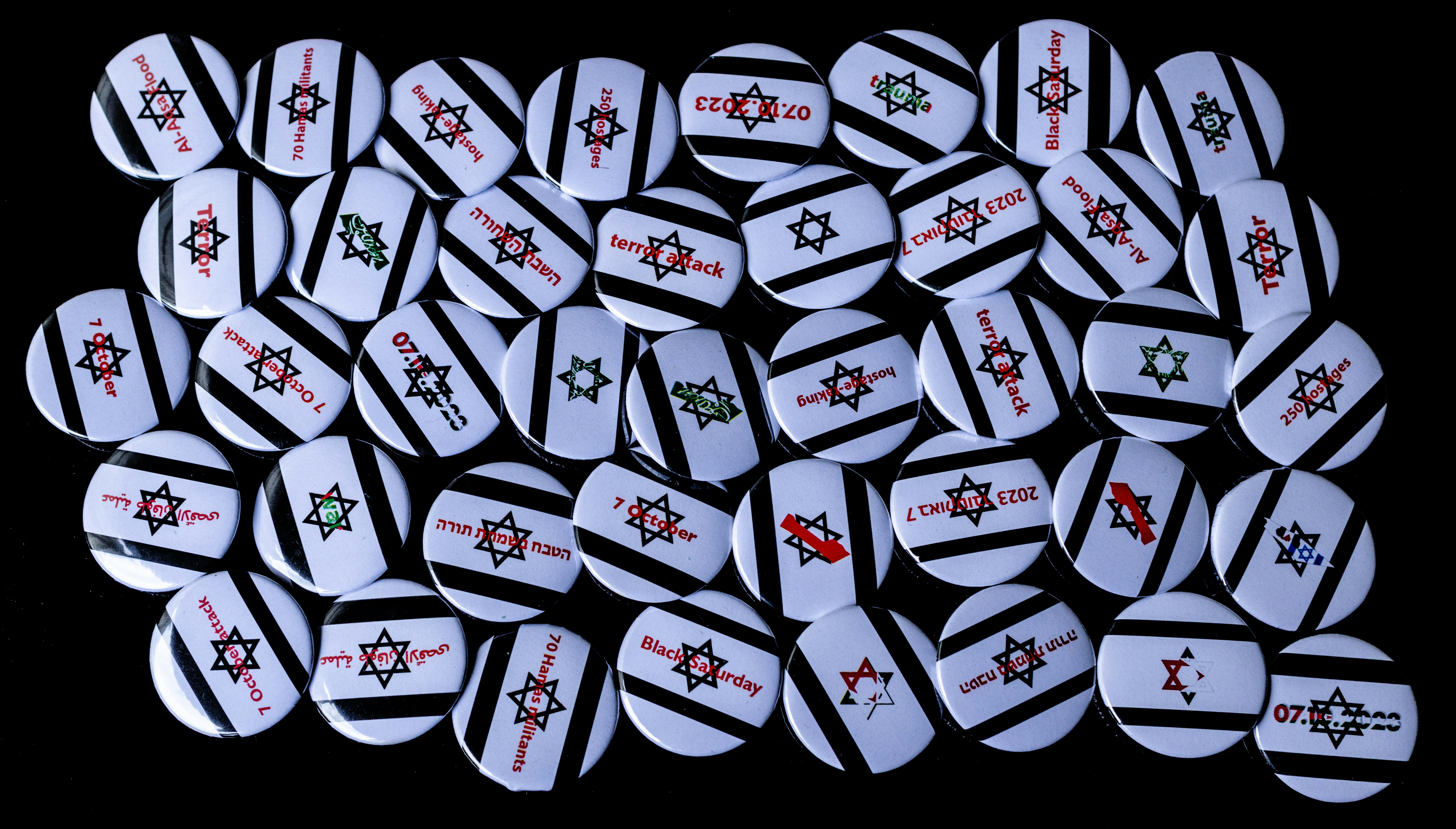 A pile of white and red buttons on a black background