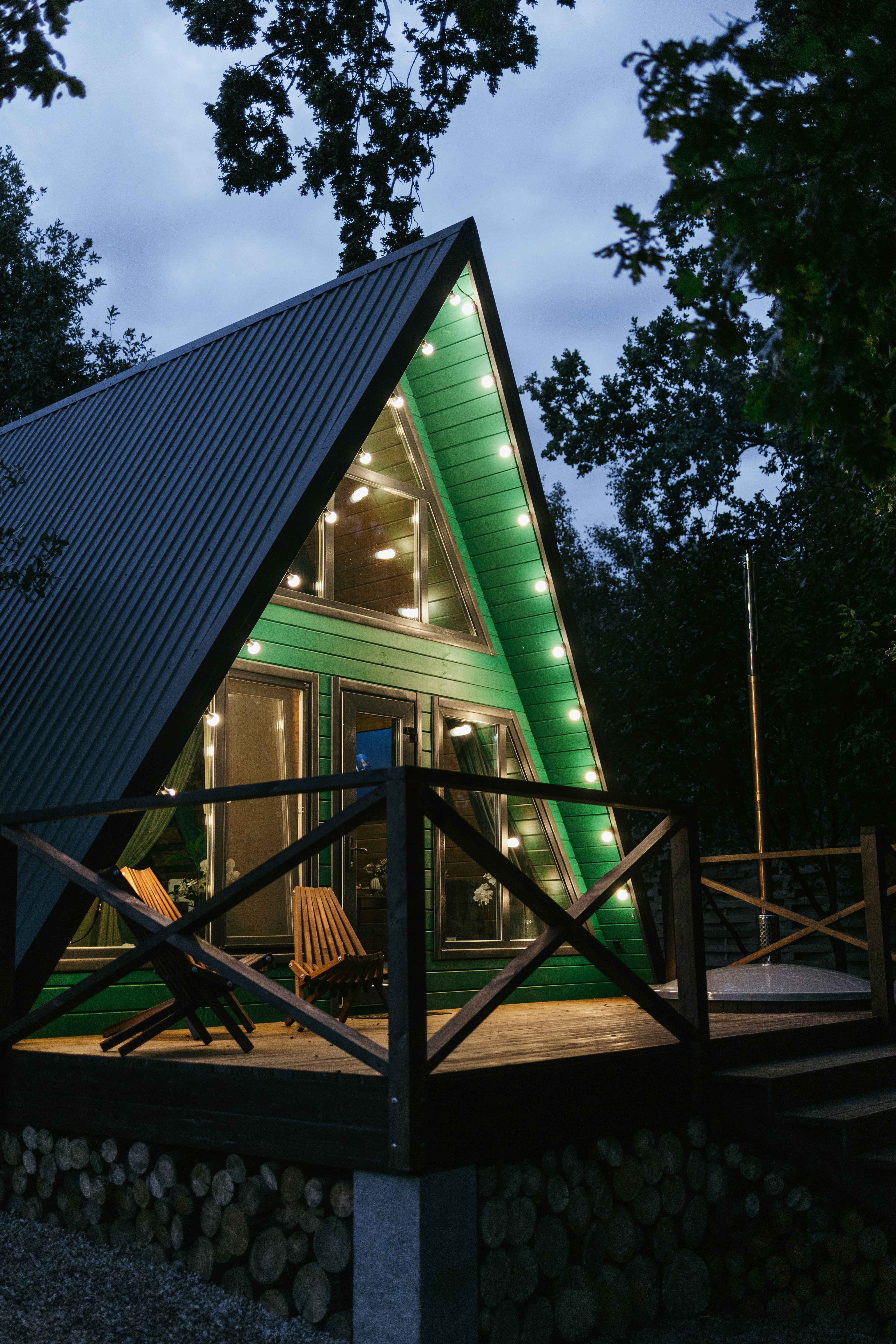 A house with a green roof and lights on it