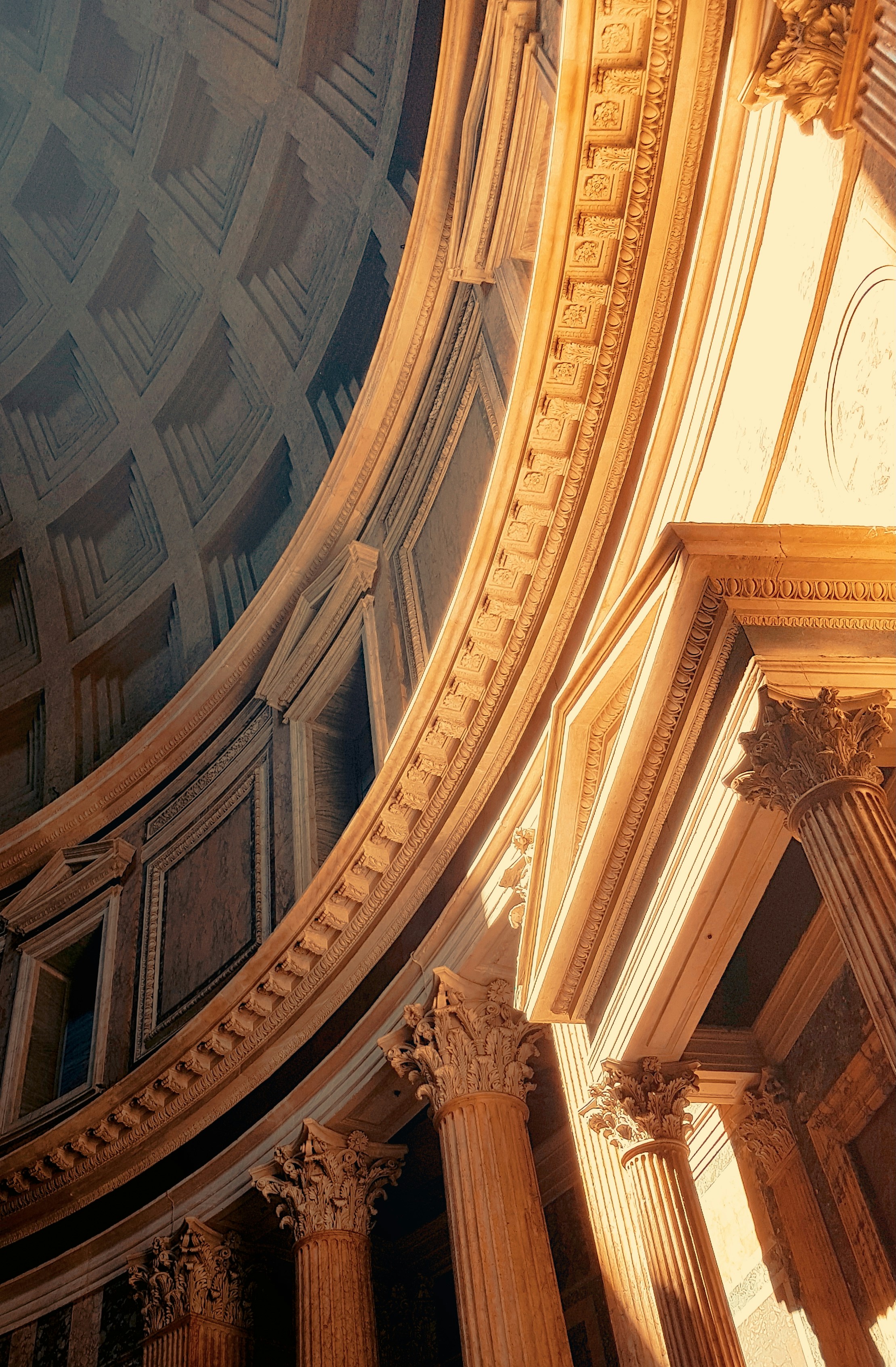 The ceiling of a building with columns and a clock