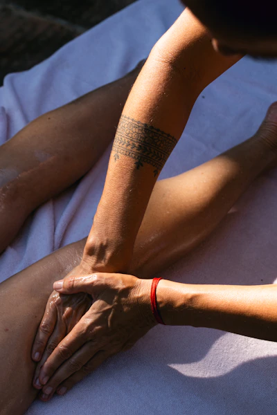 A person with a tattoo on their arm sitting on the ground