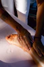 A person is doing a foot massage on a bed