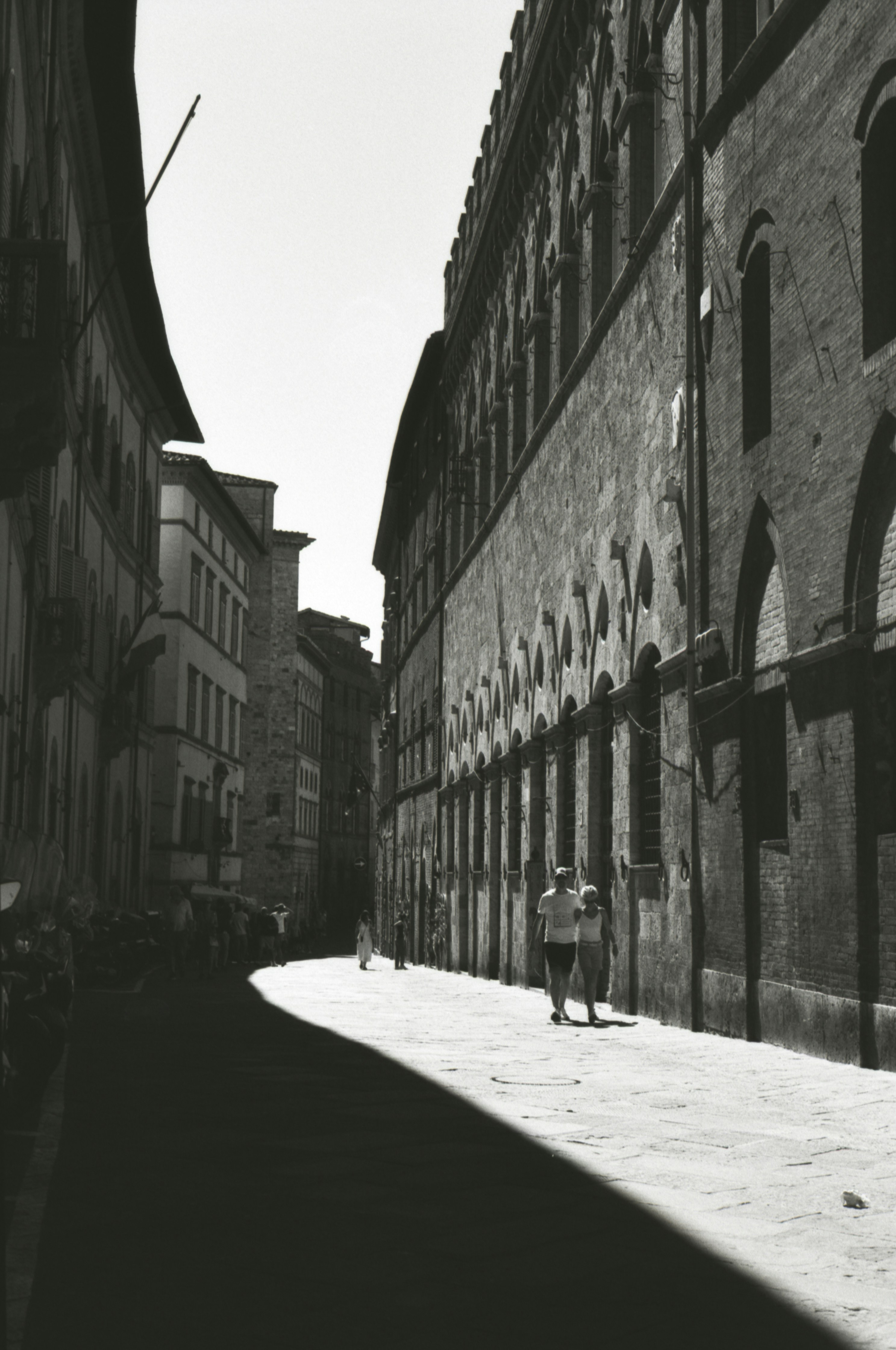 A black and white photo of a person walking down a street