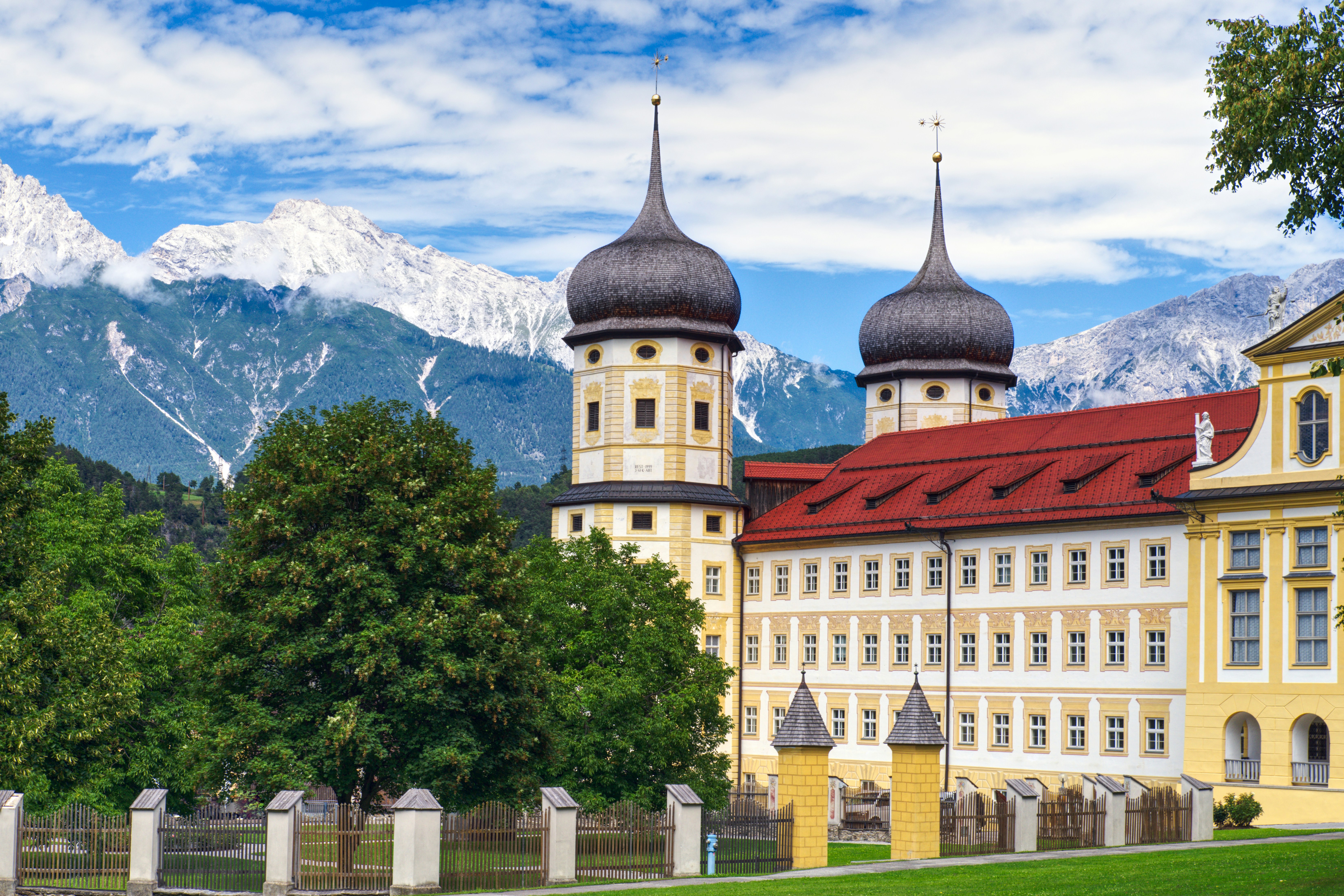 A large yellow building with two towers and a red roof